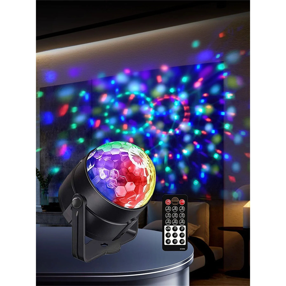 Ein Discokugel-Lichtprojektor mit Fernbedienung. Das Licht projiziert bunte Muster an die Wand.