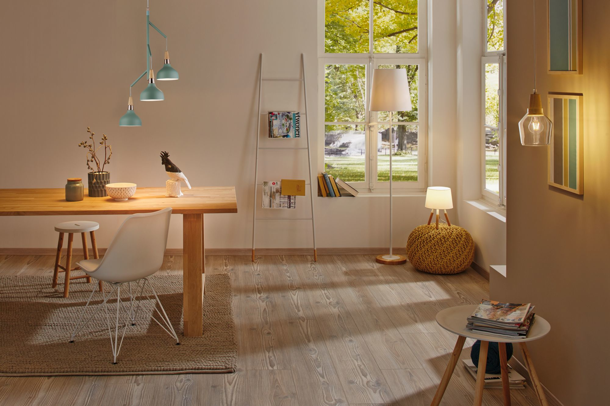 Una scena di sala da pranzo con un tavolo di legno, sedie e varie lampade. Luce naturale attraverso una finestra.