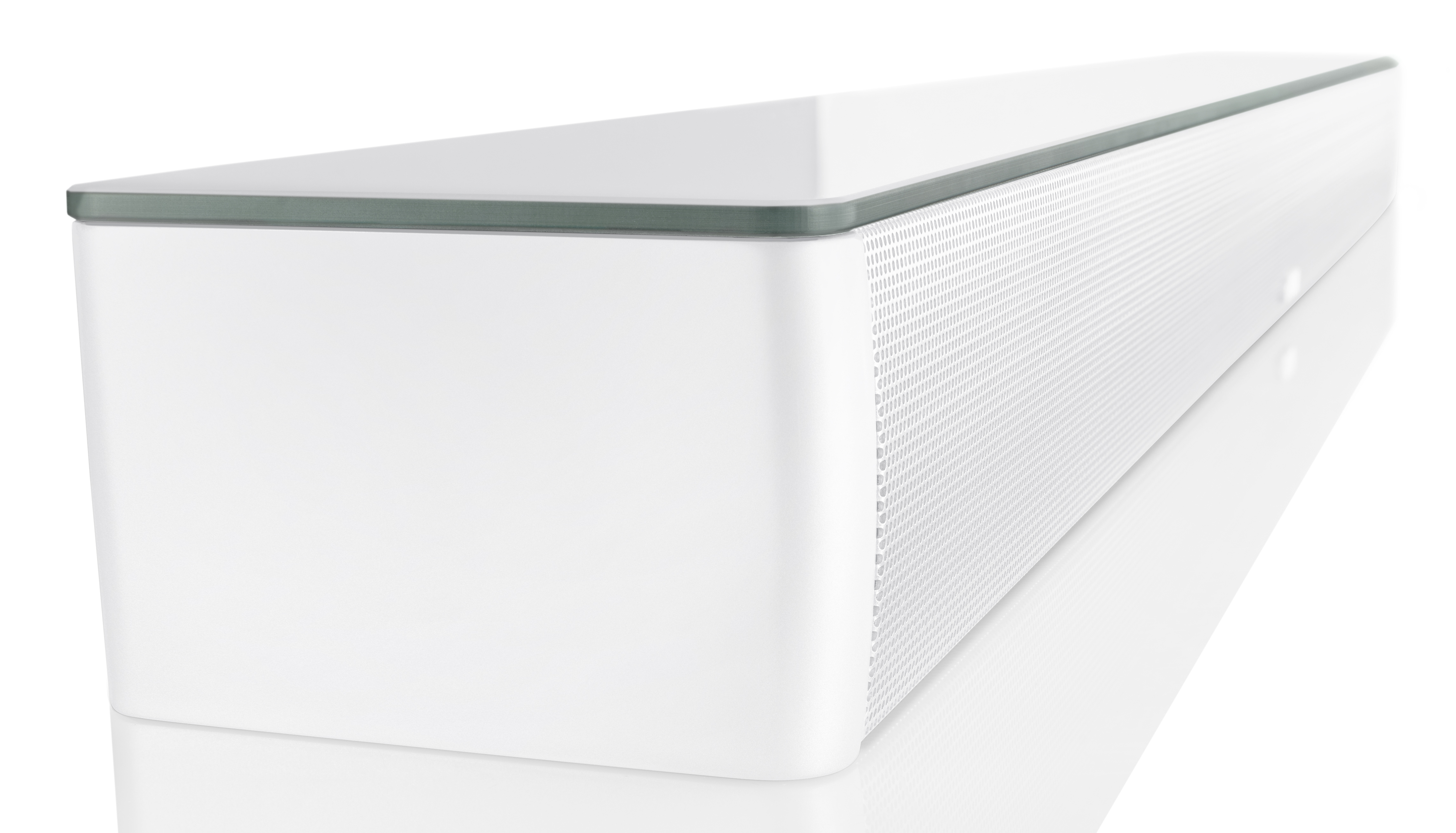 Biały soundbar z perforowanym przodem. Ma szklany blat i białą powierzchnię. Białe tło.