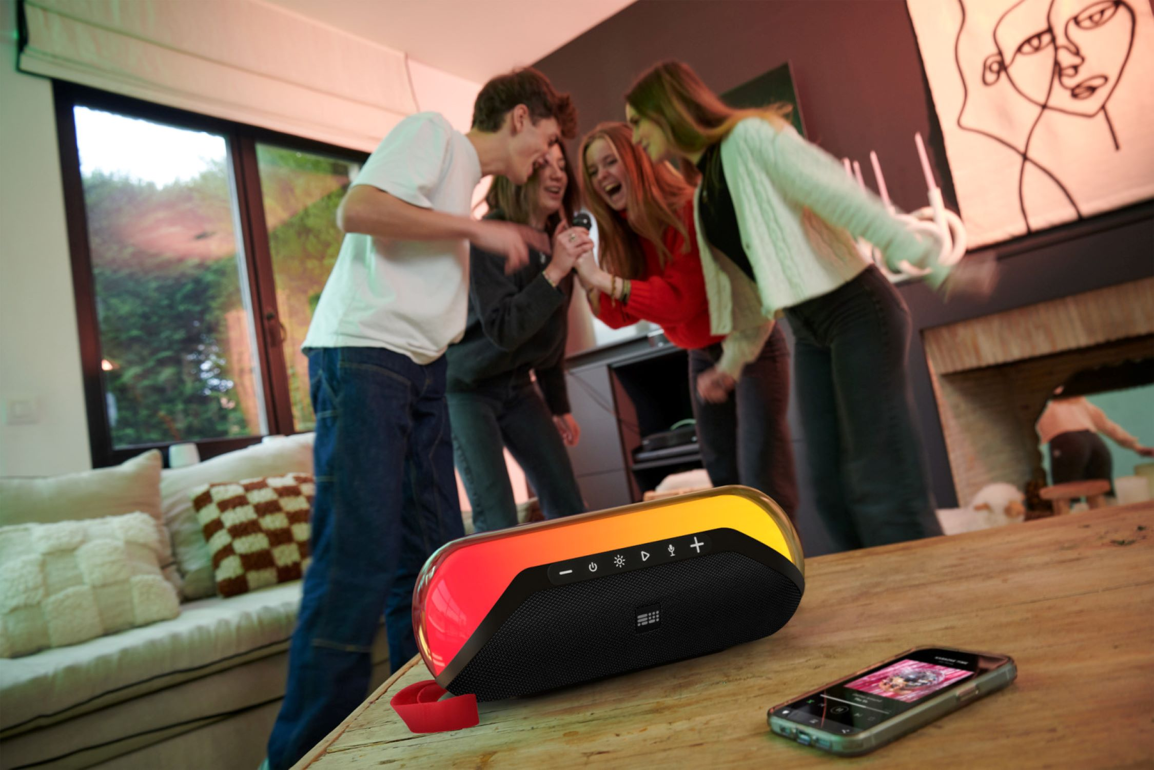 Grupa ludzi śpiewających do mikrofonu, z głośnikiem i telefonem na pierwszym planie.