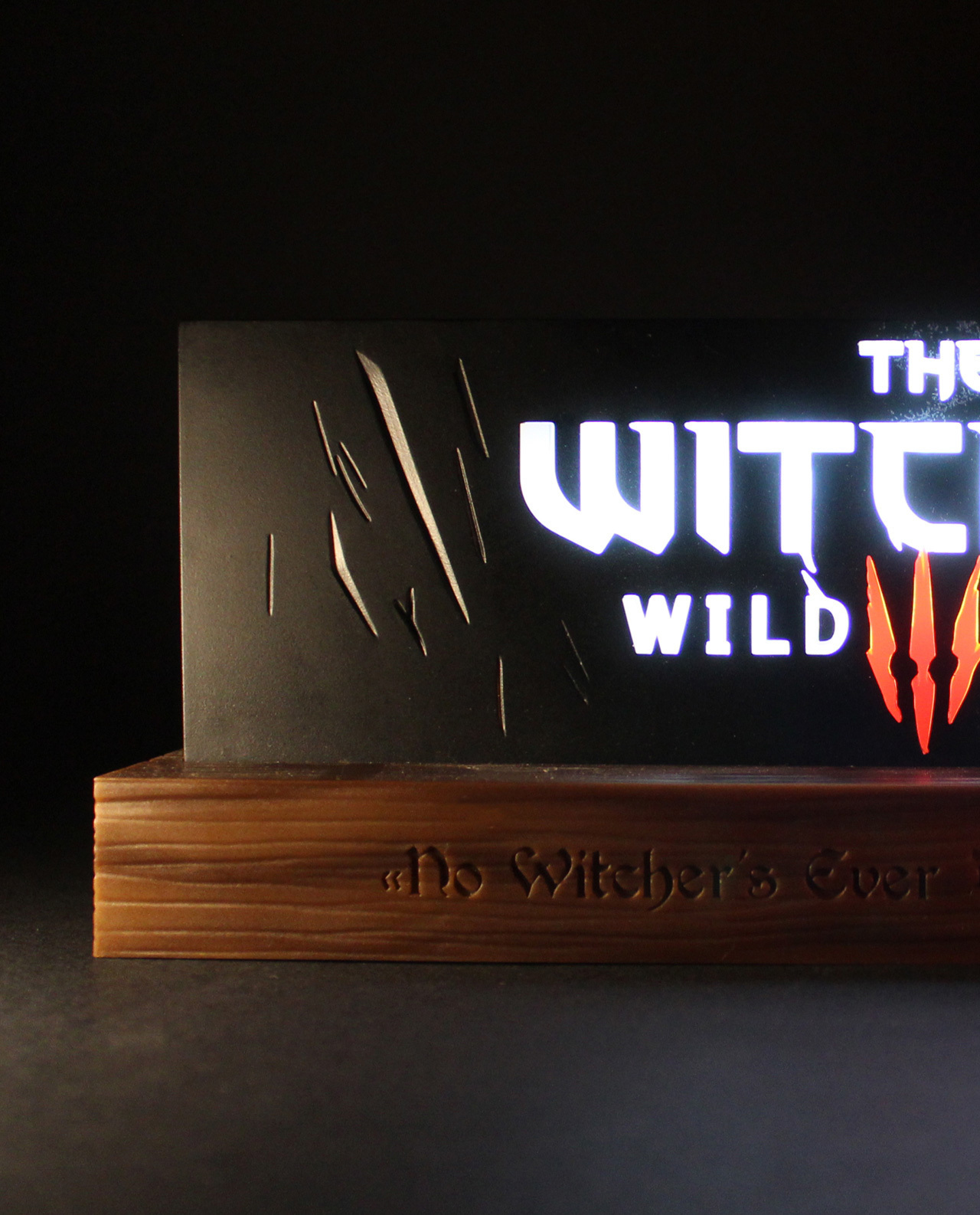 L'insegna di The Witcher con le parole 'WILD HUNT' e simboli rossi. Base in legno.