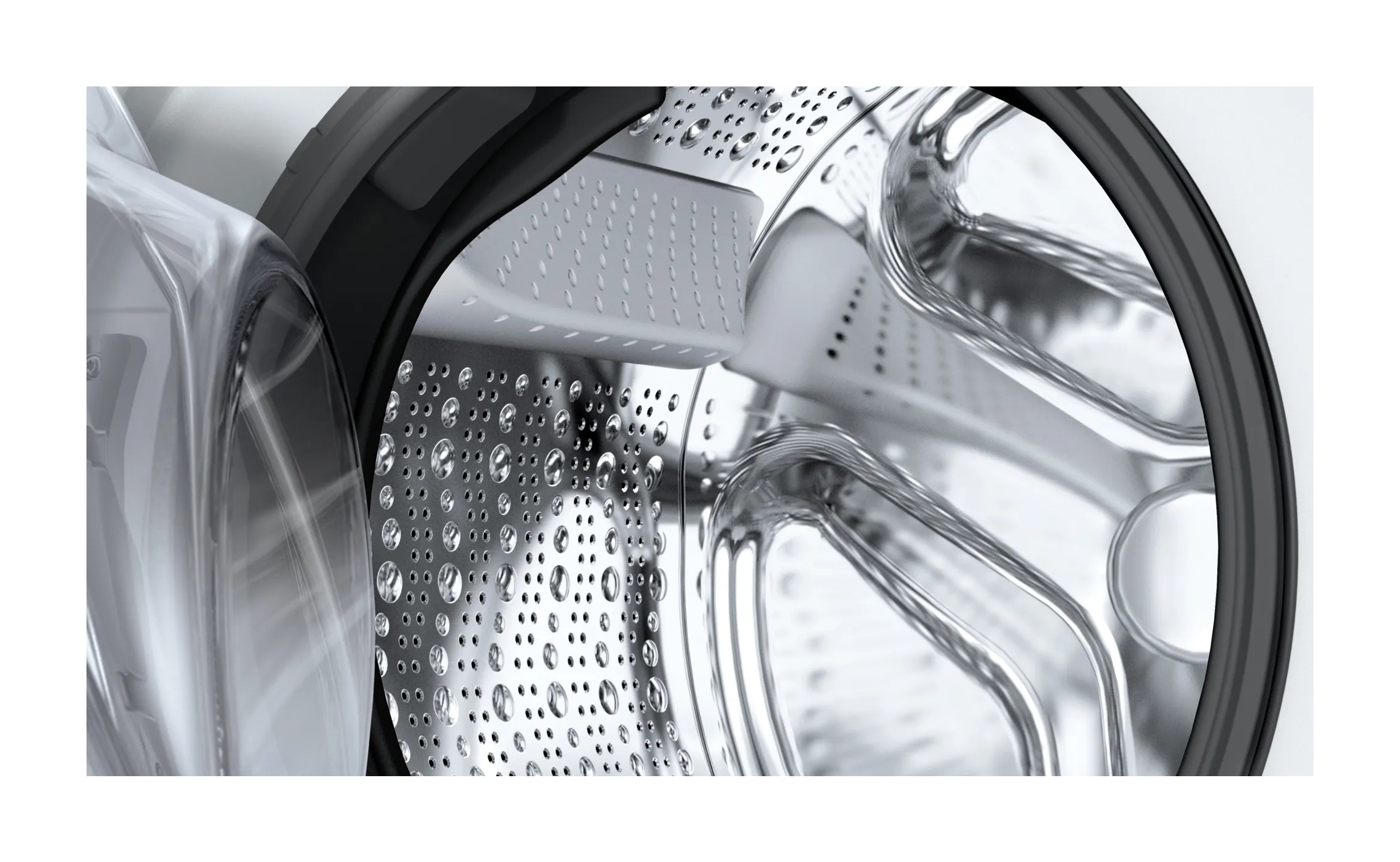 Zbliżenie na wnętrze pralki. Bęben jest srebrny i ma otwory. Drzwi są otwarte.