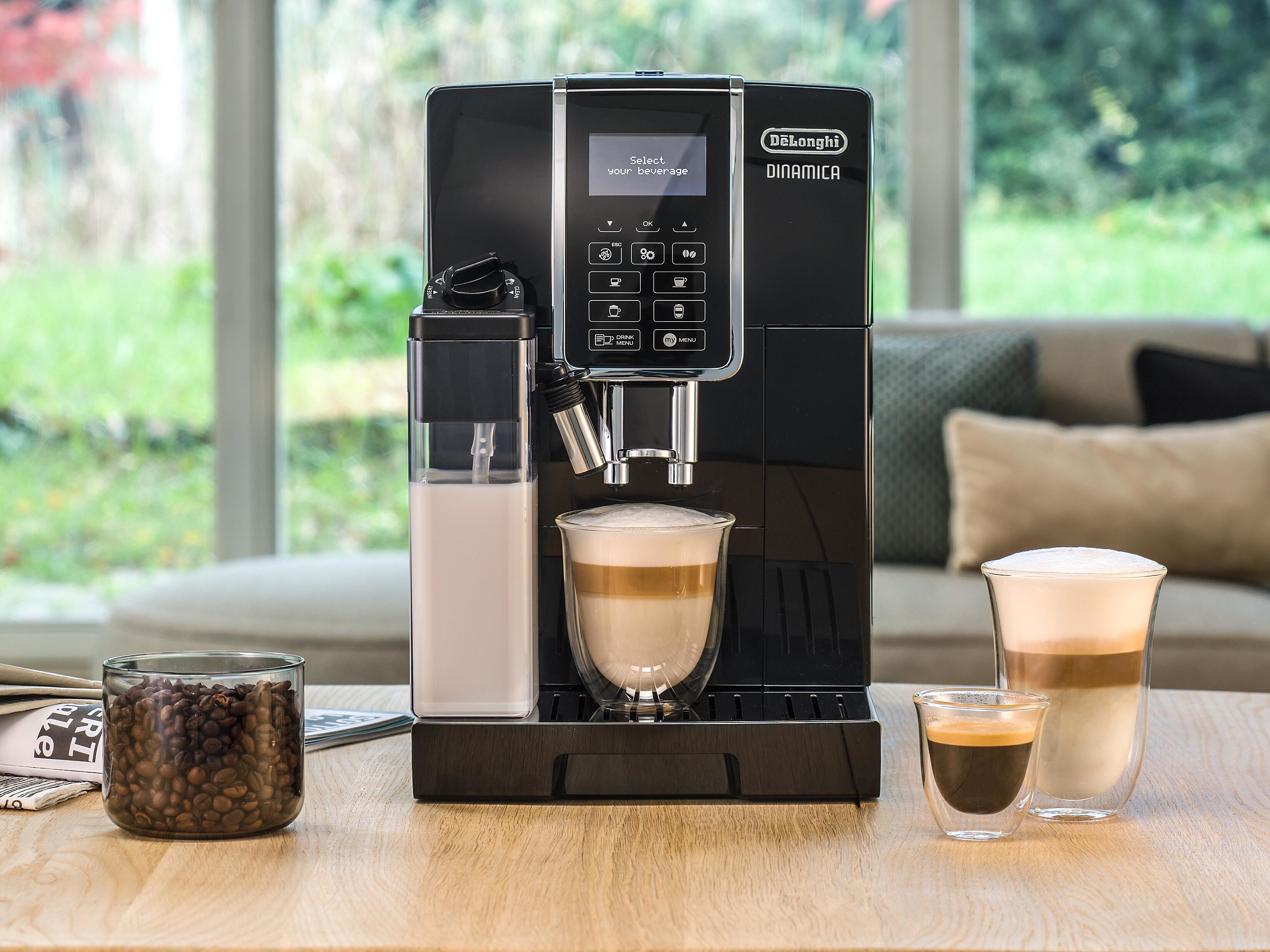 Eine schwarze DeLonghi Kaffeemaschine mit Kaffee und Milch in Gläsern.