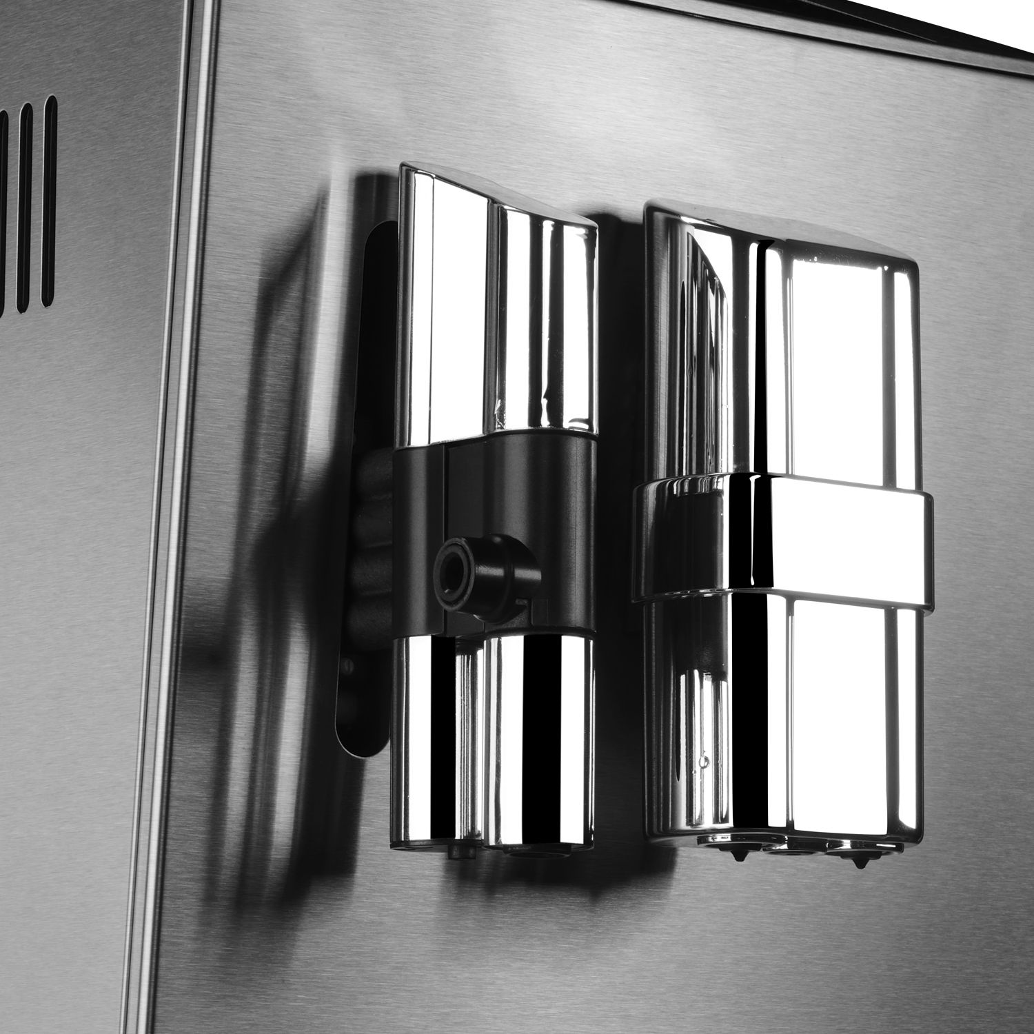 Szczegóły ekspresu do kawy: metaliczna srebrna powierzchnia z czarnymi elementami. Zbliżenie na dysze pary.