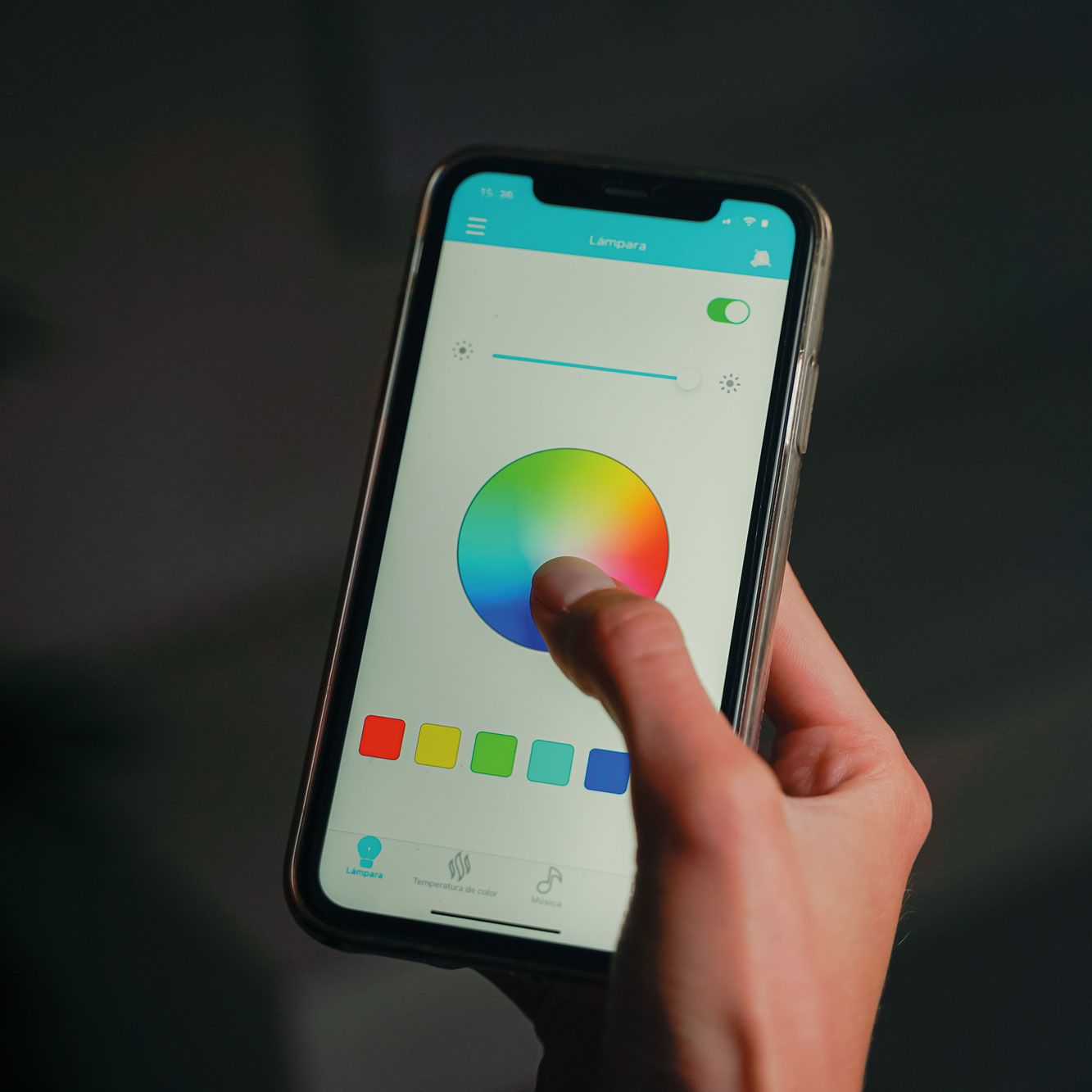 Dłoń trzymająca smartfon z aplikacją koła kolorów.