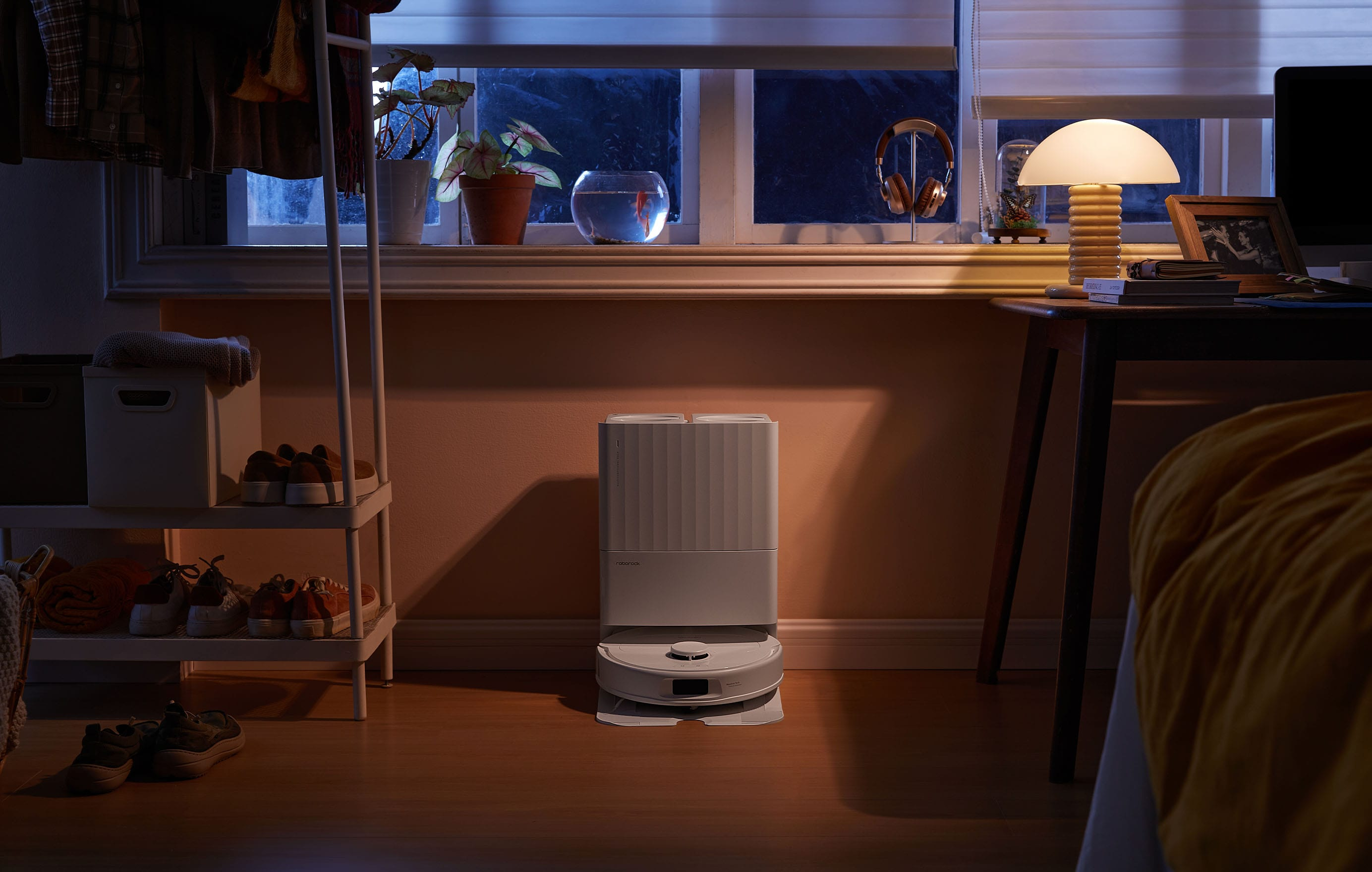 Ein Wohnzimmer mit einem Roboter-Staubsauger. Fenster, Lampe und Möbel in der Szene.