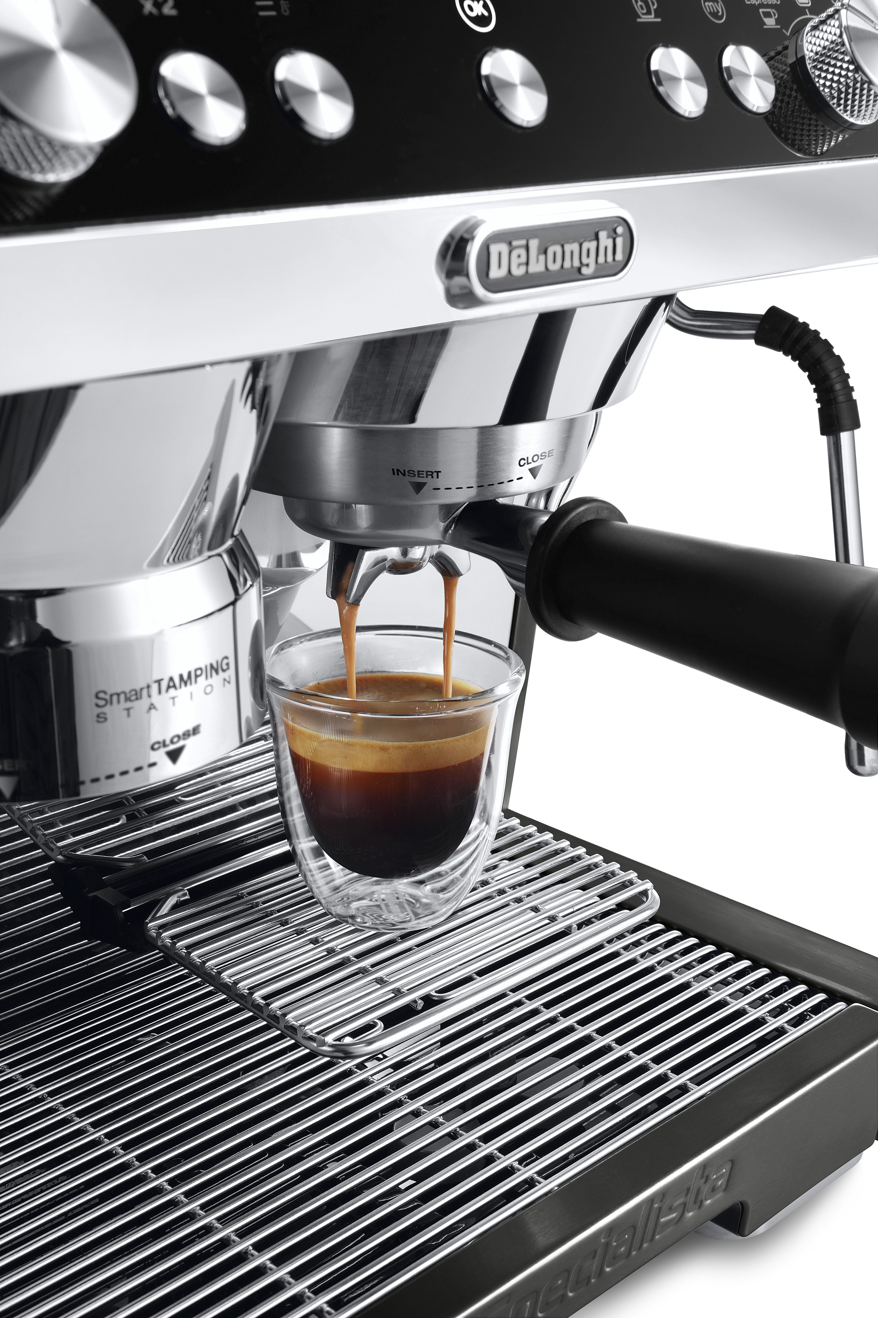 Una máquina de espresso De'Longhi dispensa un espresso doble en una taza de vidrio.