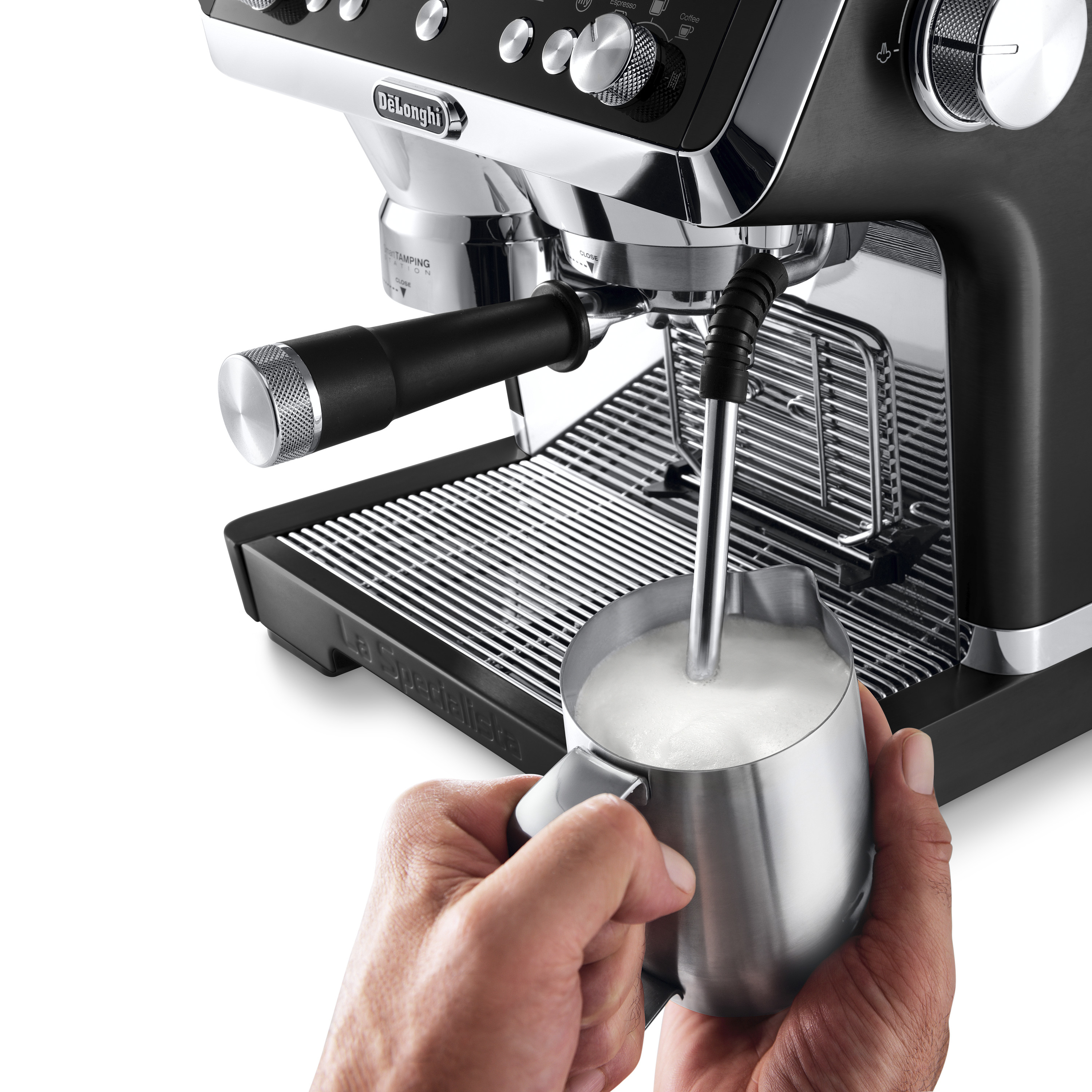 Máquina de espresso, espumando leche en una jarra plateada.