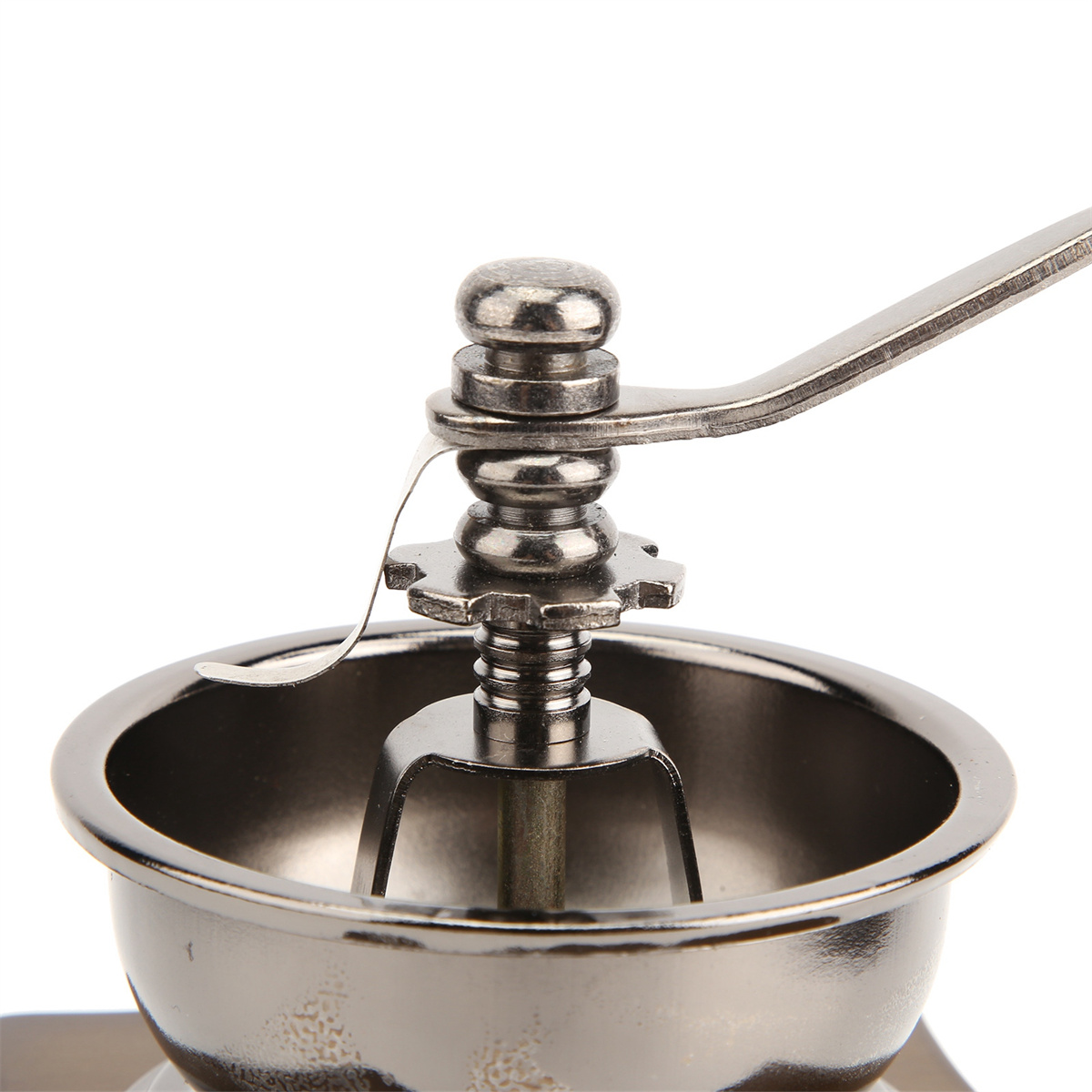 Nahaufnahme einer manuellen Kaffeemühle. Der obere Teil mit dem Griff ist sichtbar, metallisch und glänzend.