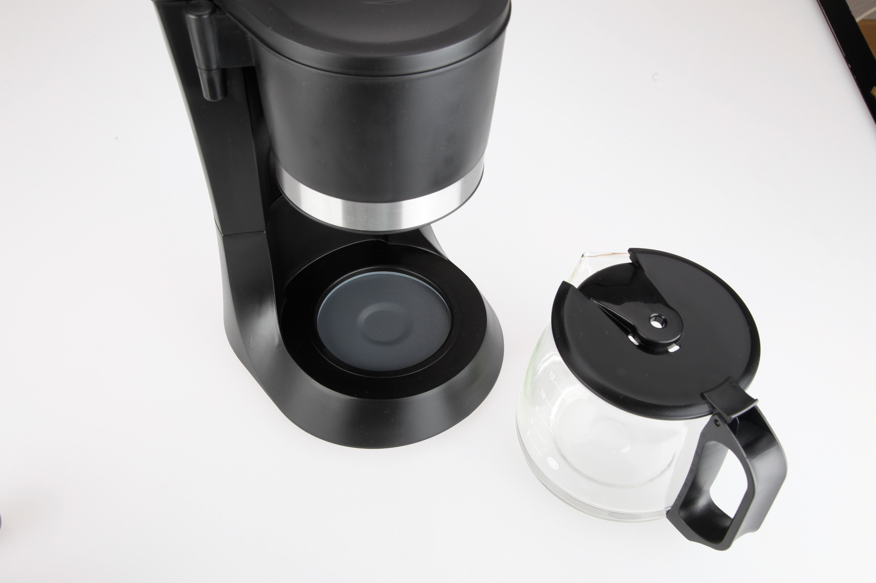 Czarny ekspres do kawy ze szklaną karafką na białym tle. Widok z góry.