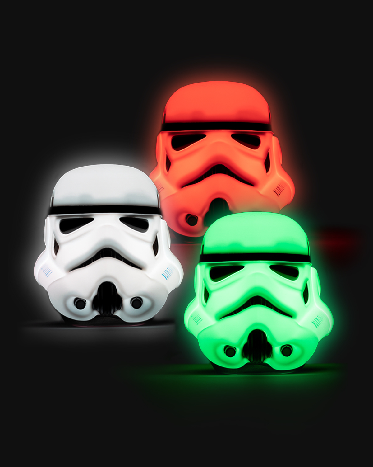 Drei leuchtende Star Wars Stormtrooper-Helm-Leuchten in Weiß, Orange und Grün auf schwarzem Hintergrund.