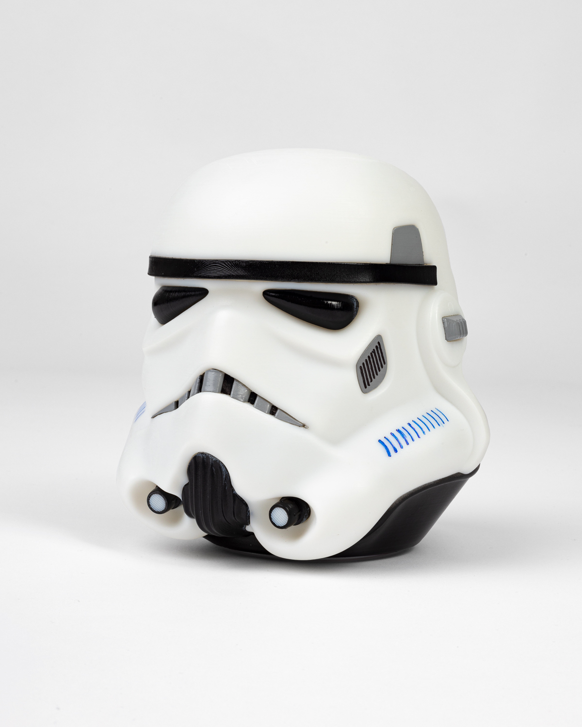 Stormtrooper-Helm-Replik in Weiß mit schwarzen Details auf weißer Oberfläche.