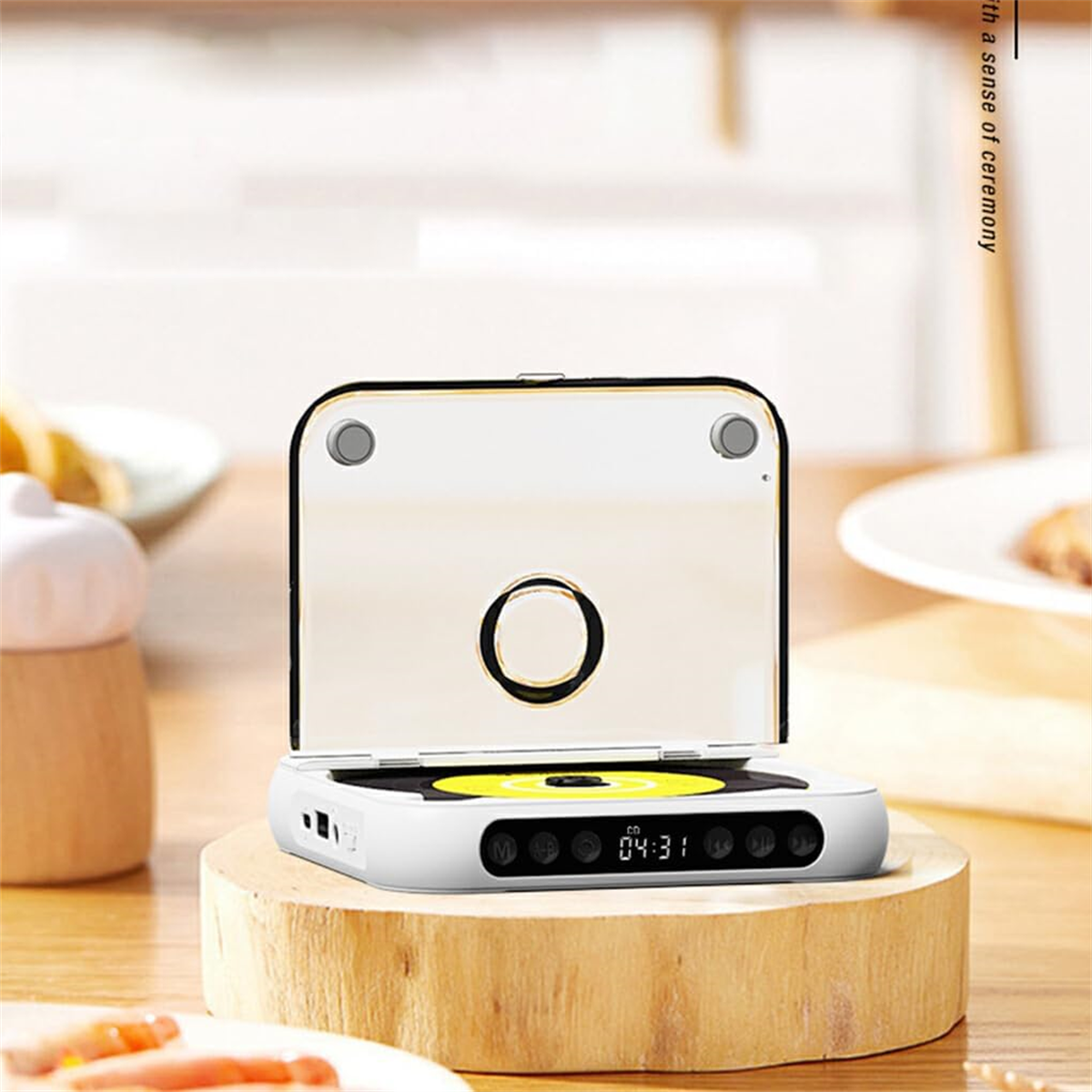 Ein weißer und goldener tragbarer CD-Player auf einem Holzständer. Er hat einen schwarzen Bildschirm und Knöpfe.