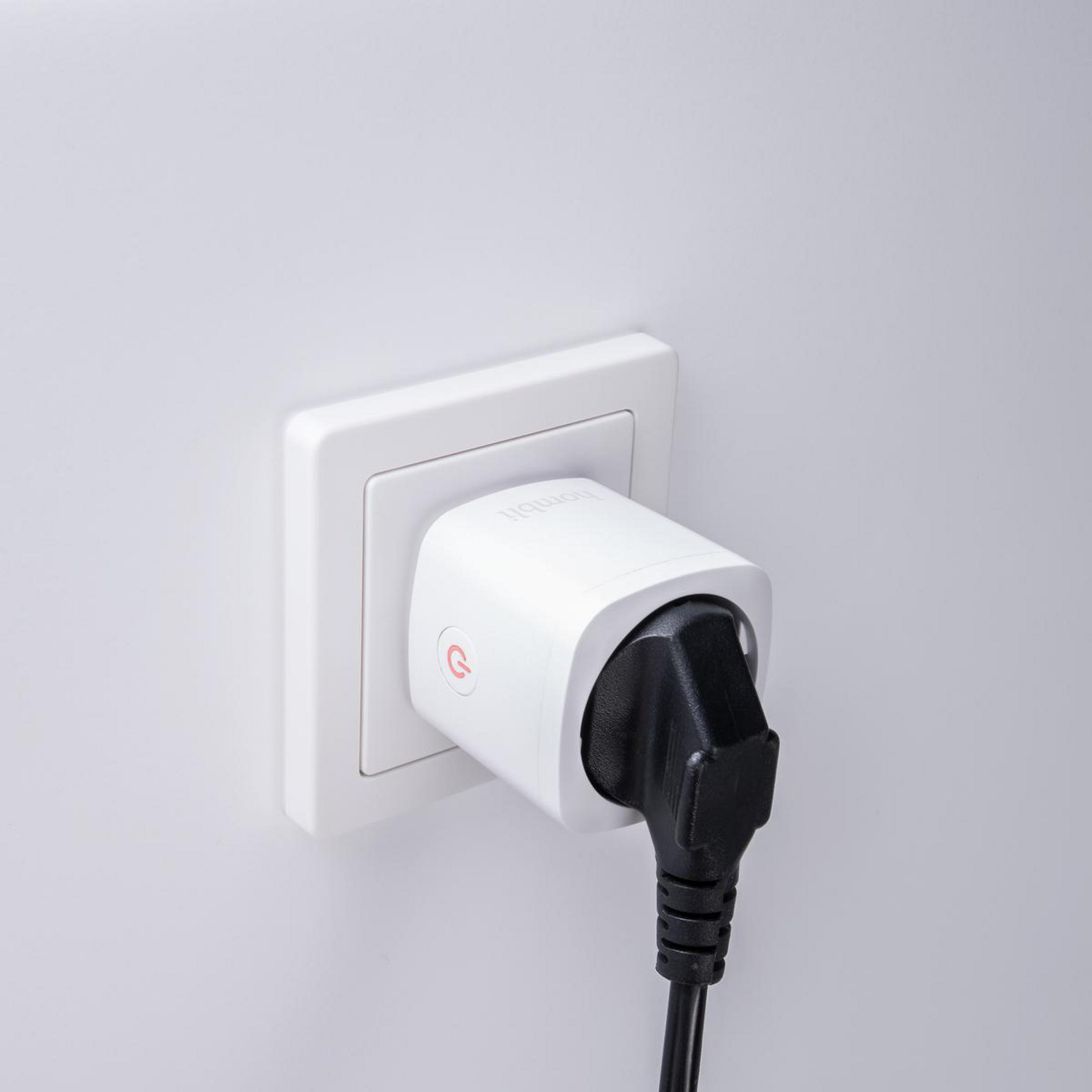 Ein weißer Smart-Stecker, der in eine Steckdose eingesteckt ist, mit einem schwarzen Stecker.