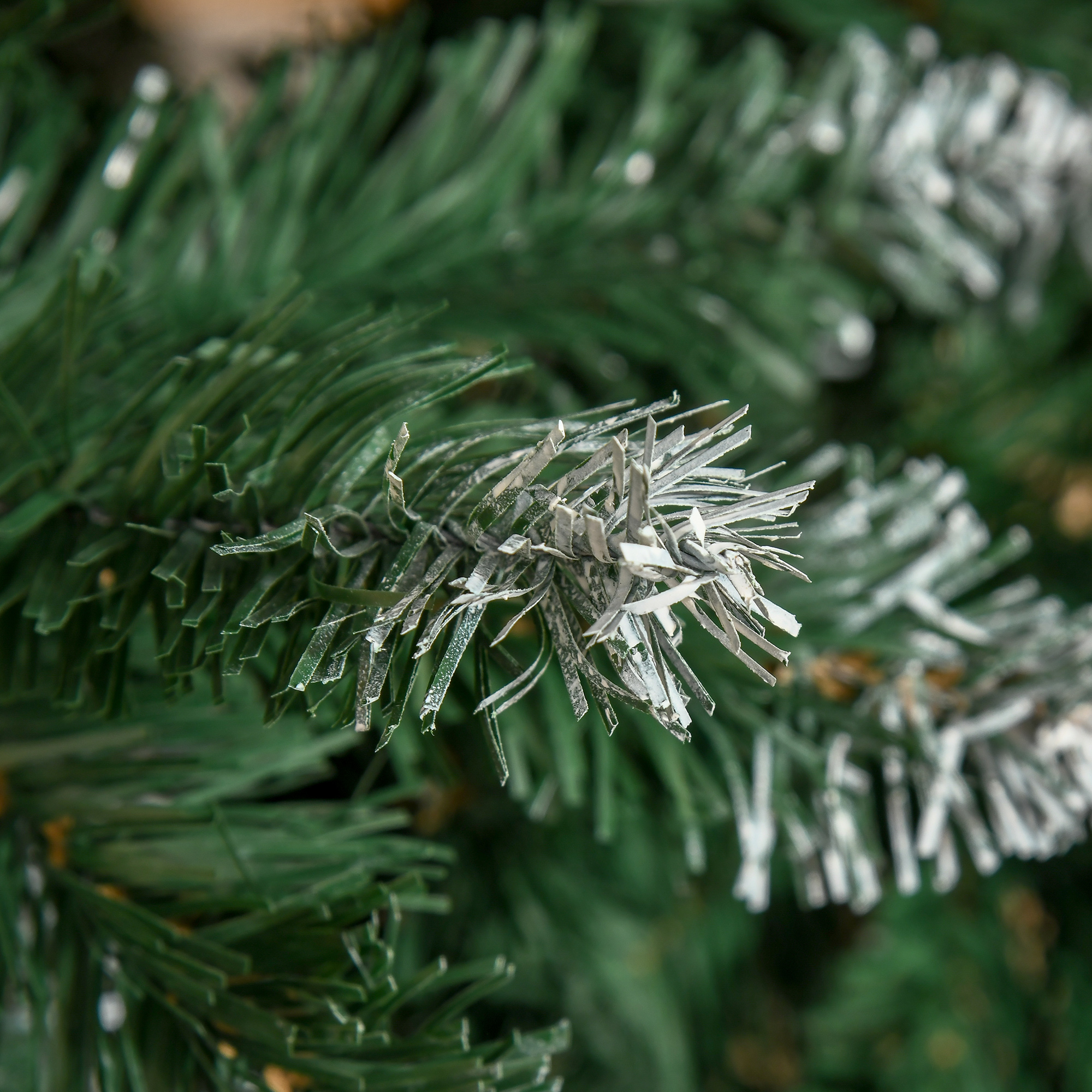 Primer plano de una rama de árbol de Navidad verde con recubrimiento de nieve.
