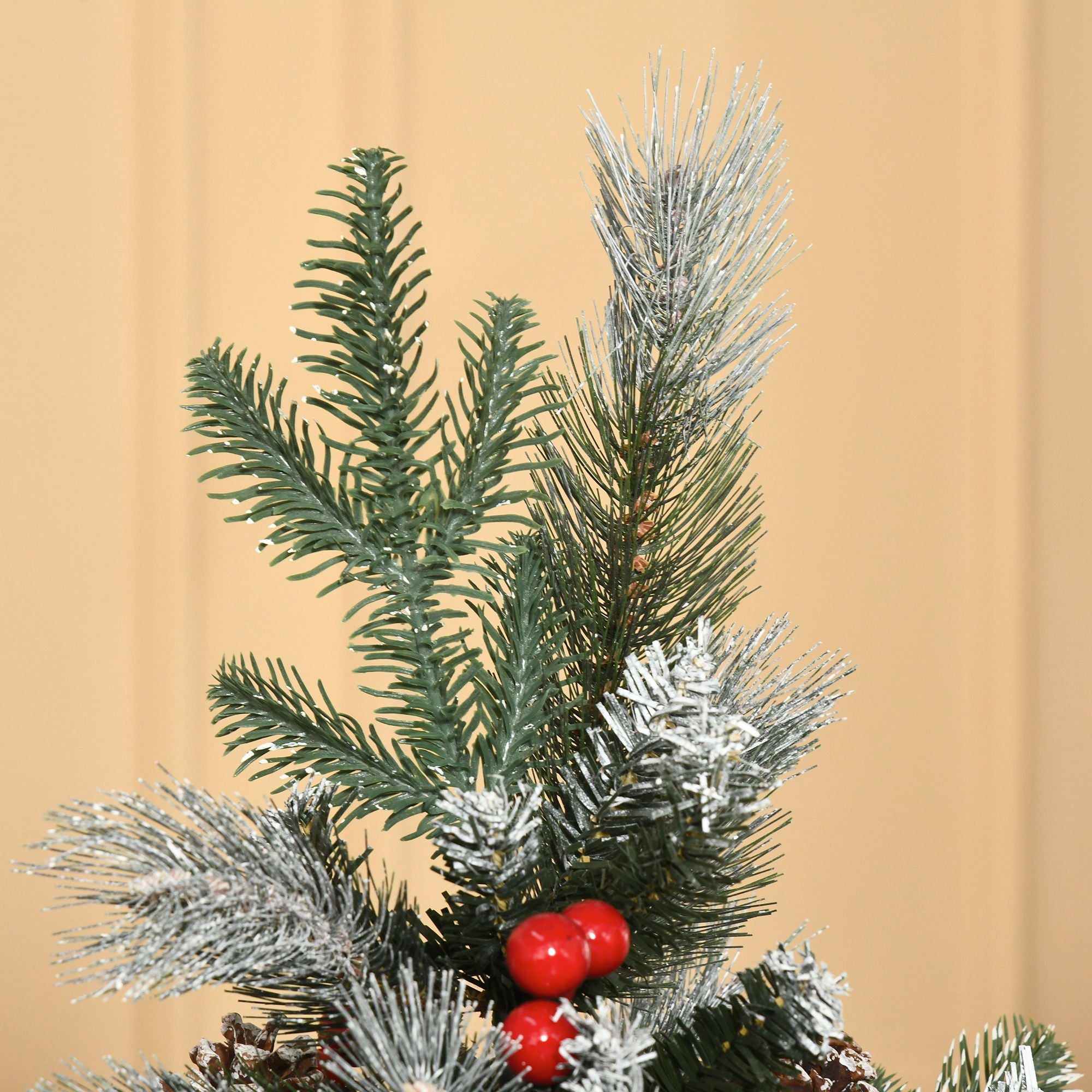 Primer plano de una rama de árbol de Navidad con nieve y bayas.