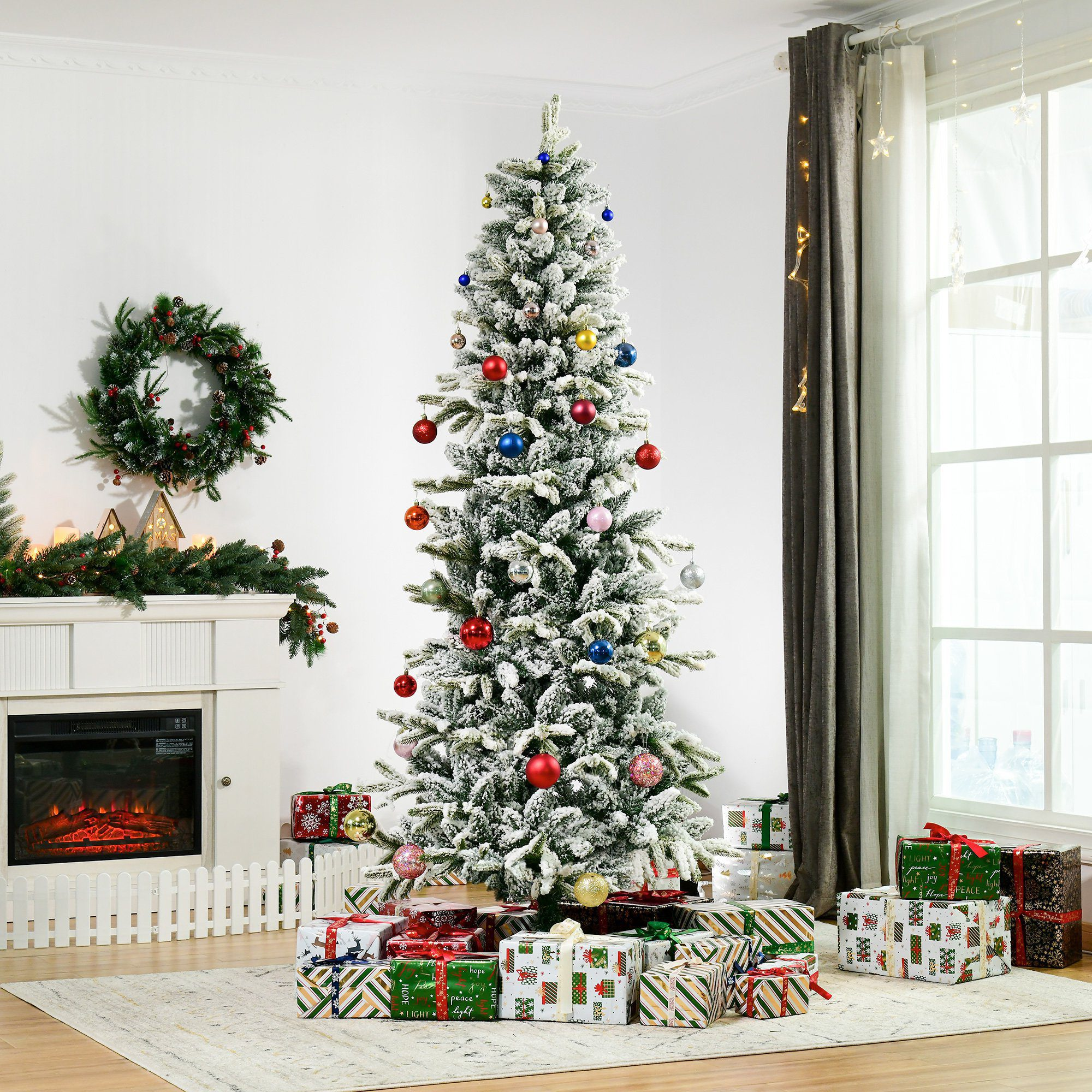 Un árbol de Navidad decorado está en una habitación con regalos. Una corona y una chimenea están en el fondo.