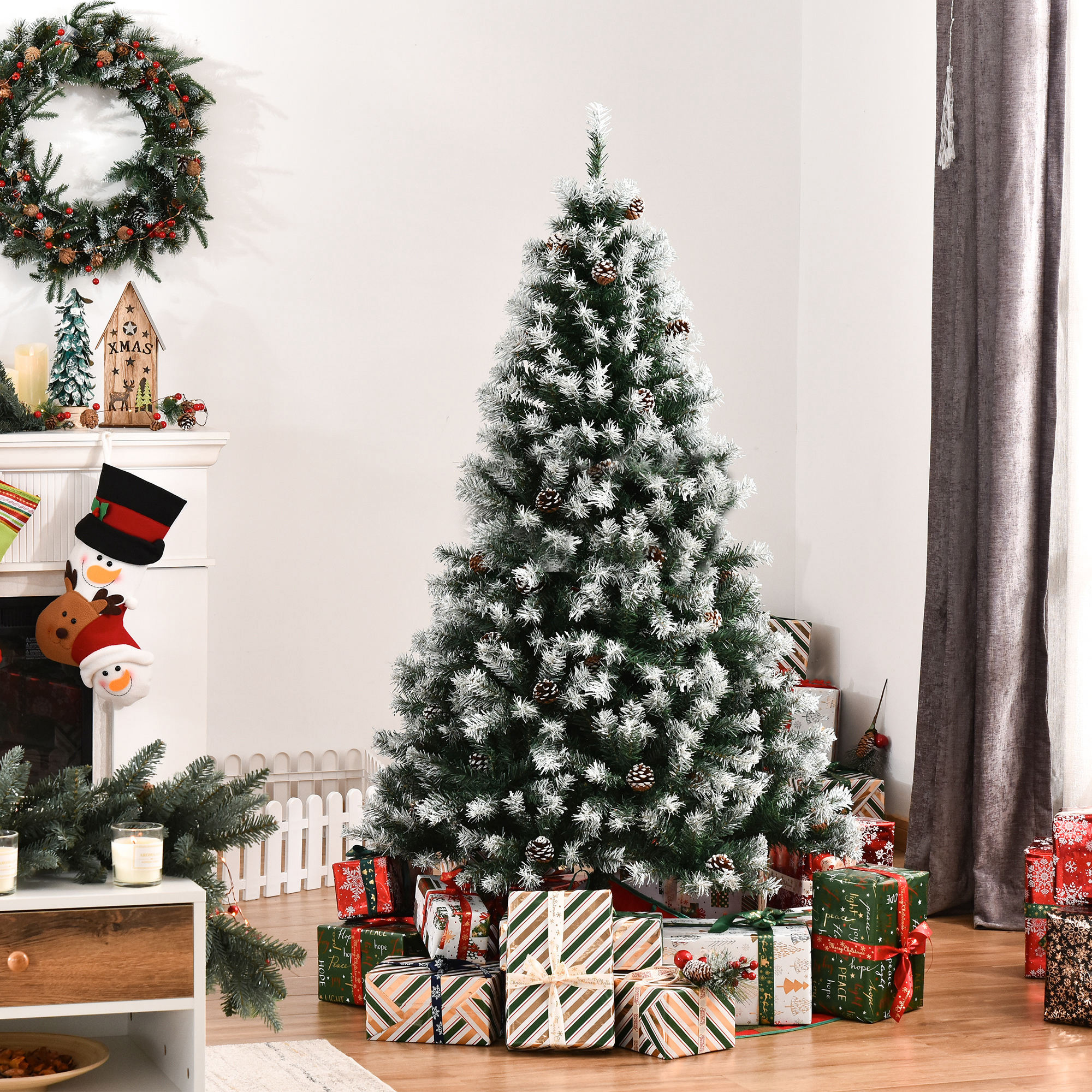Un árbol de Navidad nevado con piñas, rodeado de regalos, en una sala de estar decorada.