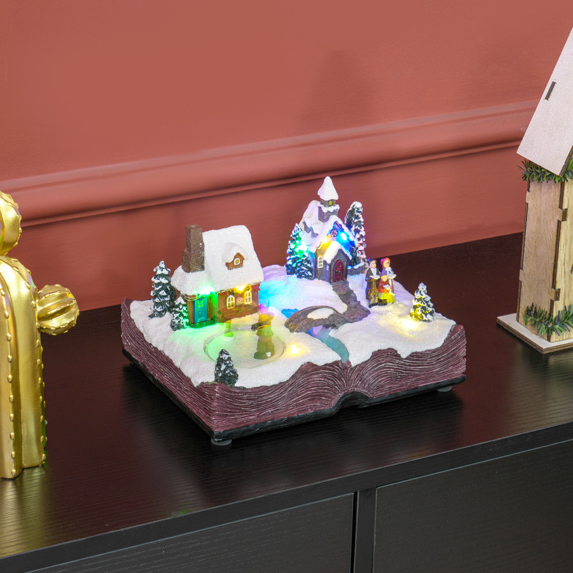 Una escena de un pueblo navideño en un libro abierto, con luces y nieve.