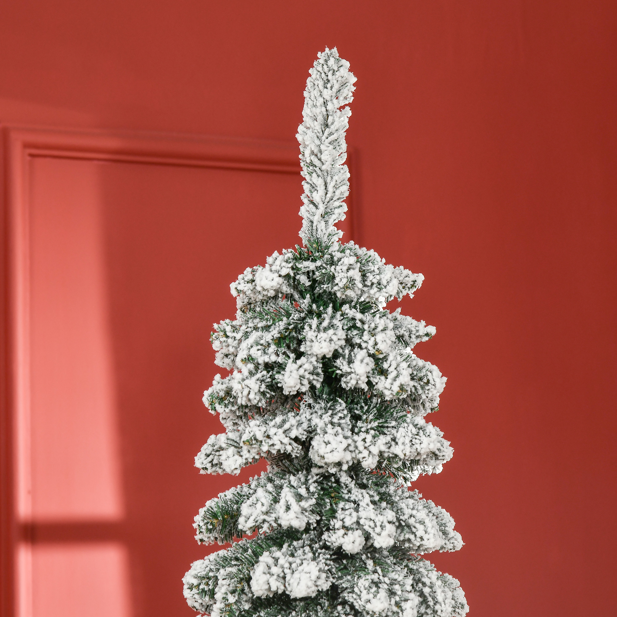 Parte superior de árbol de Navidad nevada sobre fondo rojo.