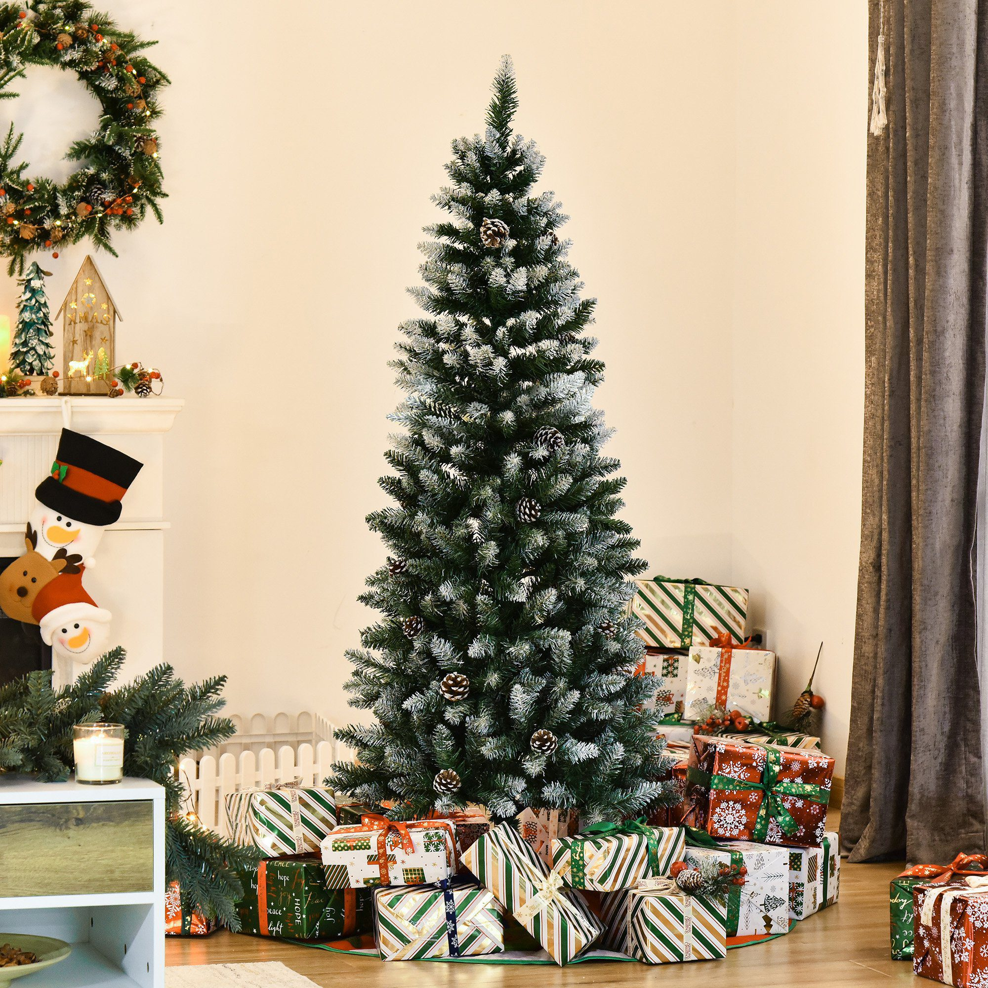Un árbol de Navidad decorado. Hay regalos debajo. Una chimenea y una corona en el fondo.