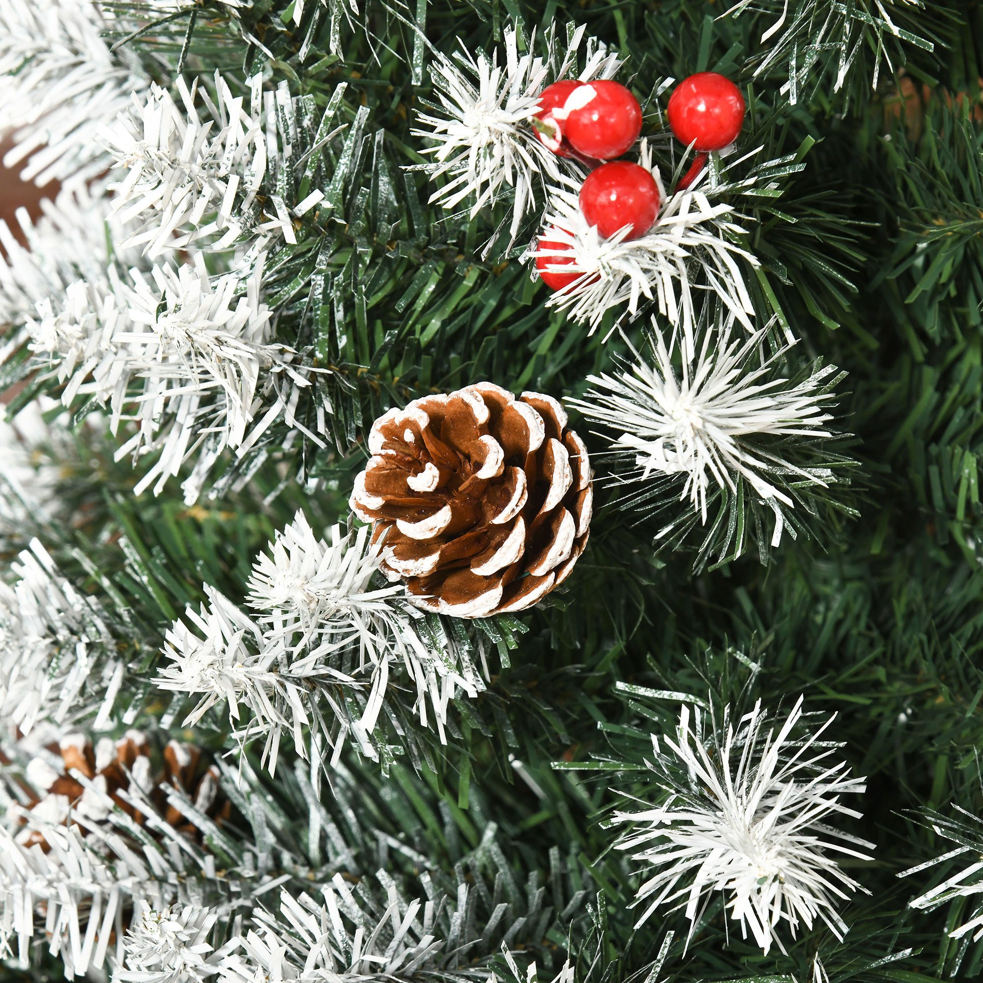 Primer plano de un árbol de Navidad con piñas y bayas rojas, cubierto de escarcha blanca.