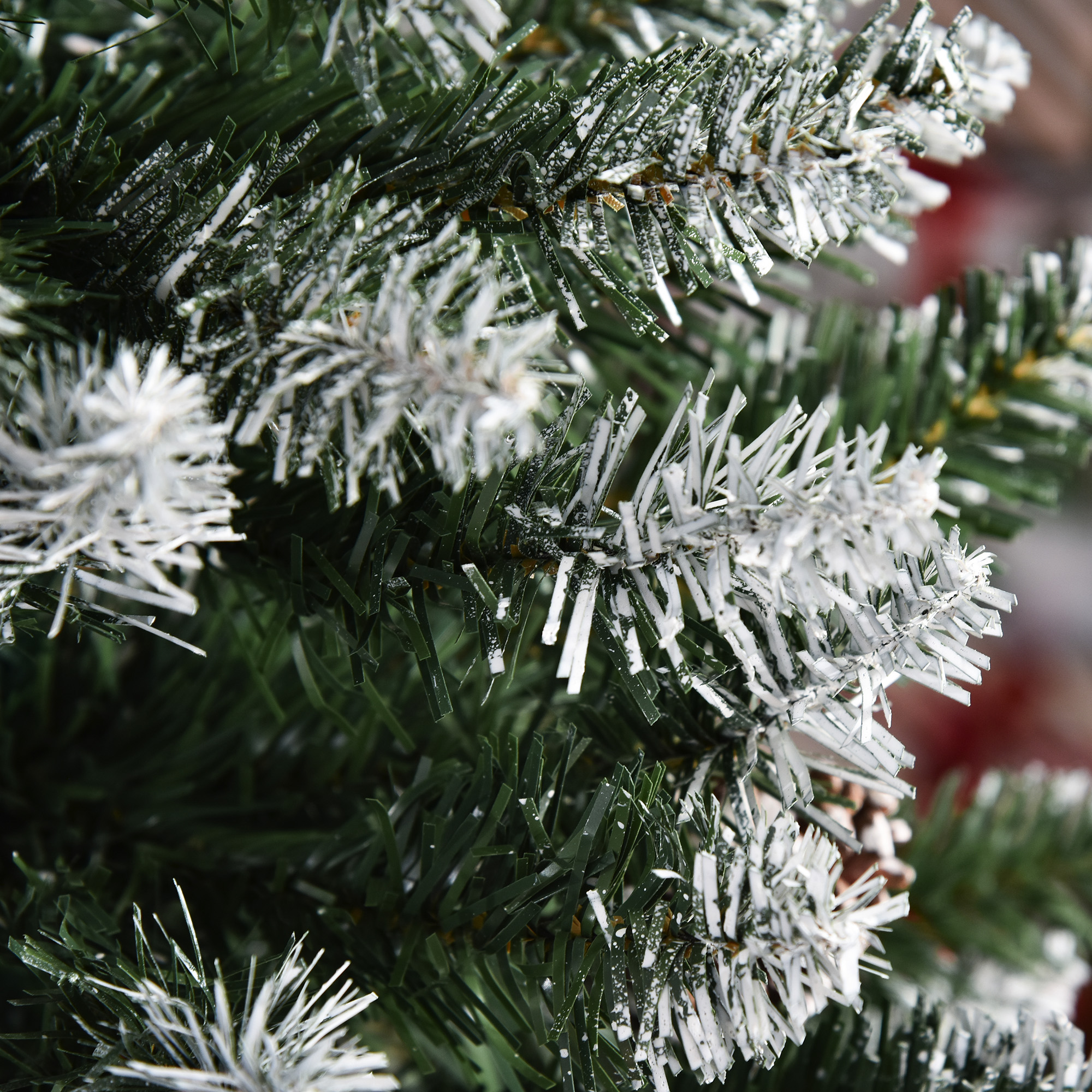 Primer plano de las ramas en forma de aguja de un árbol de Navidad nevado.