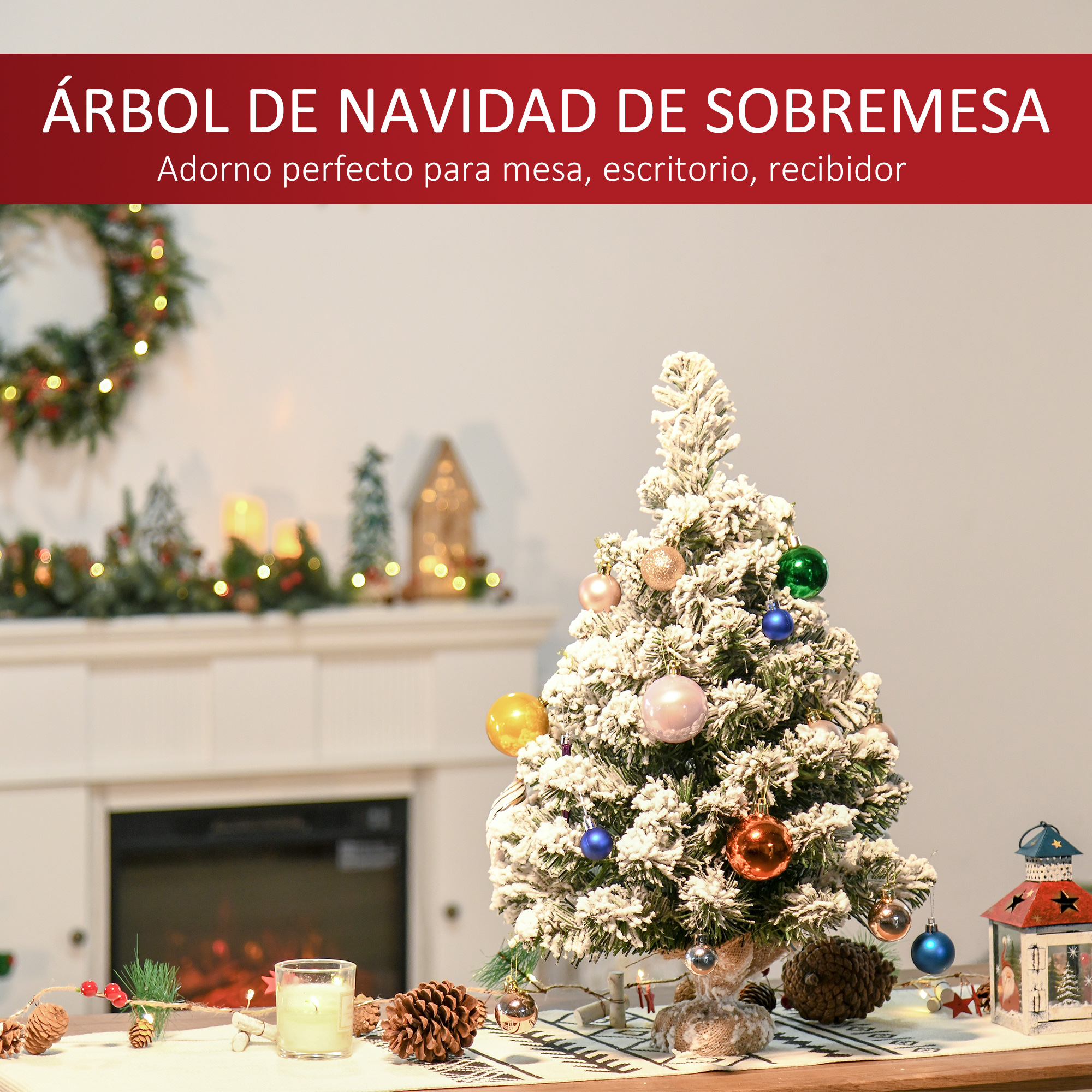 Un pequeño árbol de Navidad cubierto de nieve sobre una mesa con adornos y una vela.