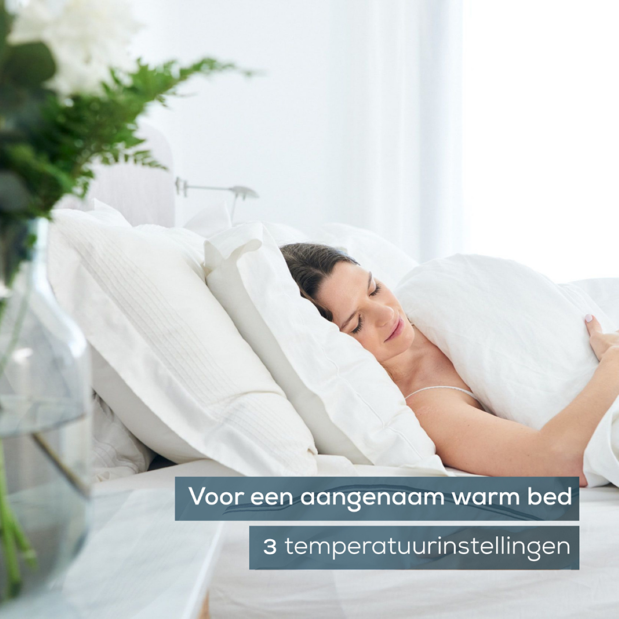 Frau schläft in weißem Bett mit Kissen. Text: Für ein warmes Bett, 3 Temperatureinstellungen.