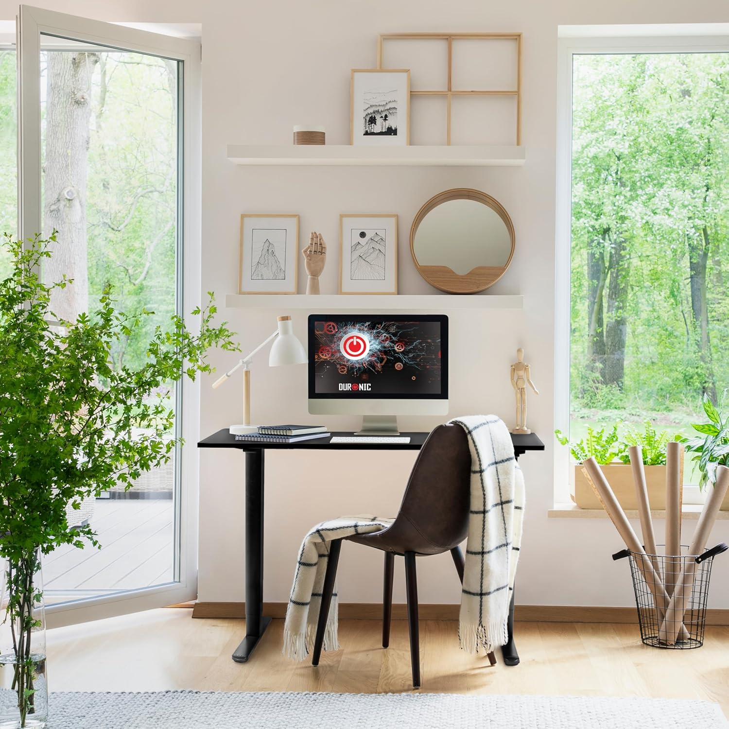 Ein modernes Heimbüro mit schwarzem Schreibtisch, Computer und Stuhl vor einem Fenster.