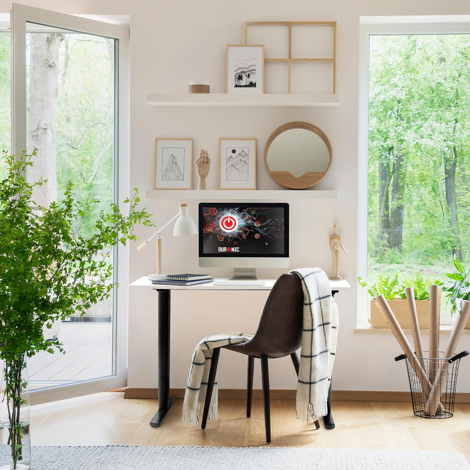 Schreibtisch mit Computer und Stuhl. Ein Fenster und ein grüner Baum sind im Hintergrund.