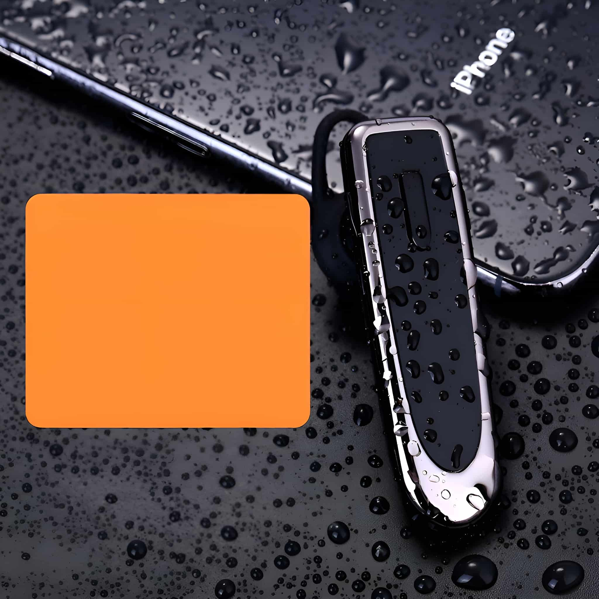 Schwarzer Kopfhörer mit nasser Oberfläche, neben einem orangefarbenen Quadrat auf nasser, schwarzer Oberfläche.