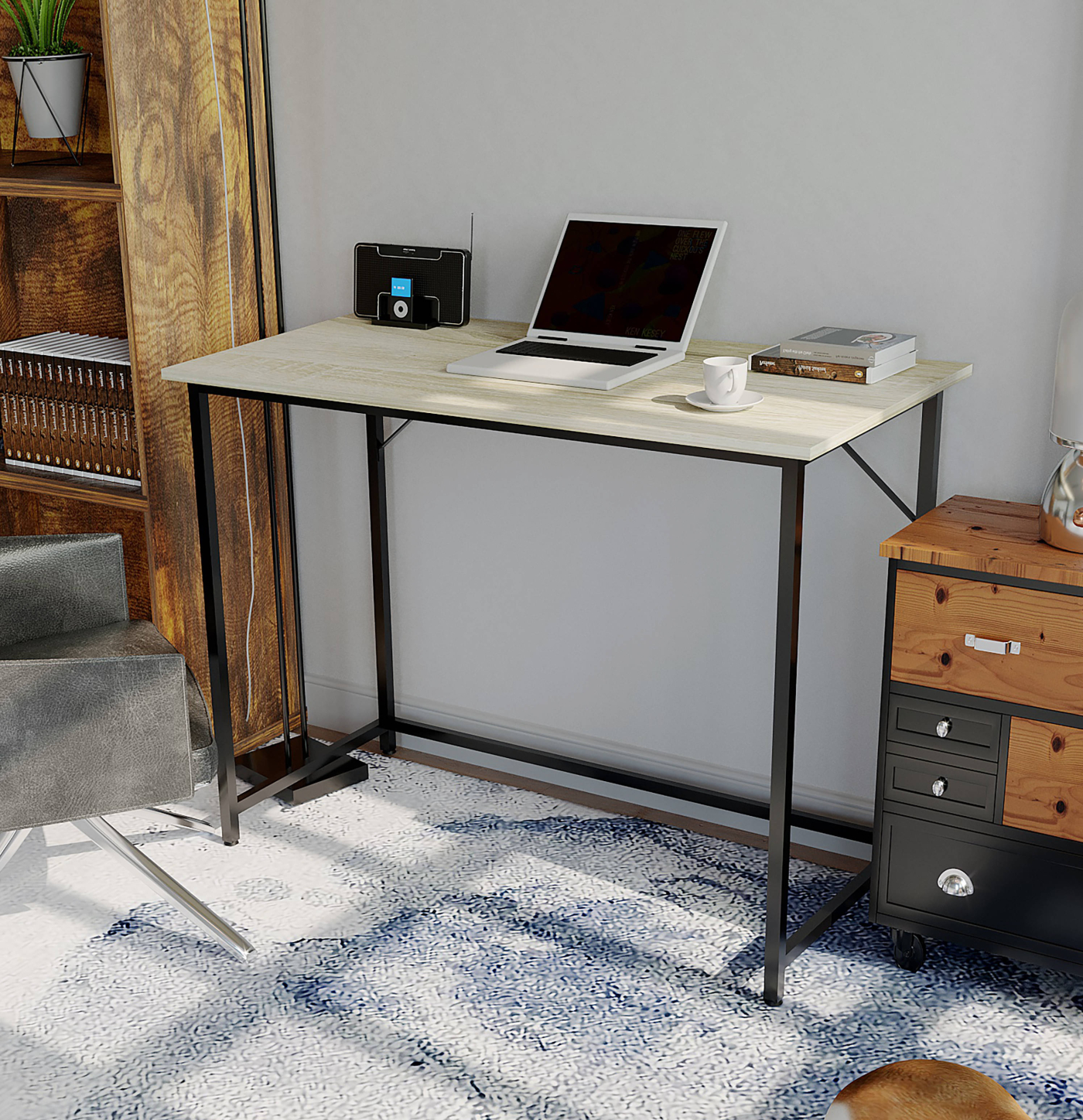 Ein Laptop auf einem Schreibtisch, ein Radio, ein Buch und ein Stuhl im Hintergrund.