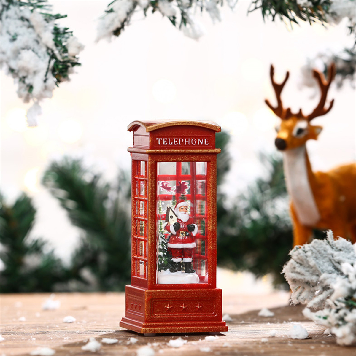 Eine Weihnachtskugel mit Santa in einer Telefonzelle, Hirsch im Hintergrund.