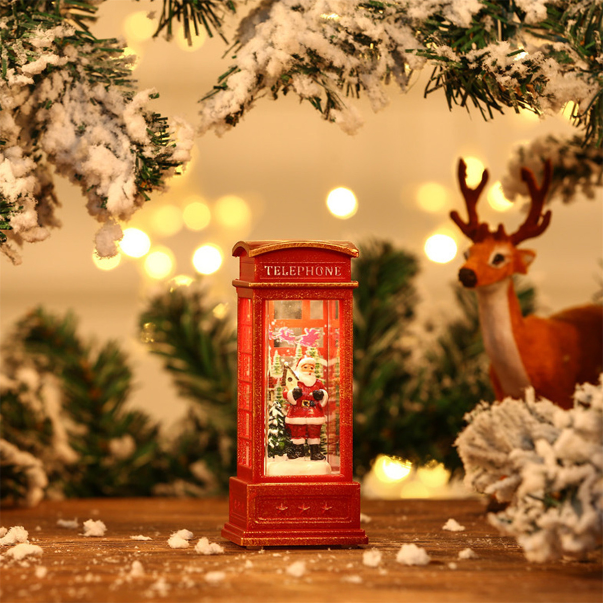 Eine Weihnachts-Schneekugel mit einer roten Telefonzelle und einer Santa-Figur. Dekoriert mit verschneiten Ästen.