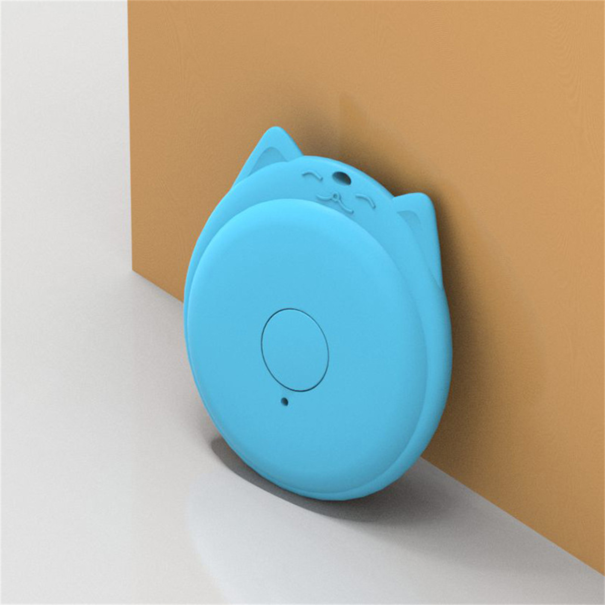 Blauer, katzenförmiger Smart-Tracker. Er lehnt an einer braunen Wand. Der Boden ist weiß.