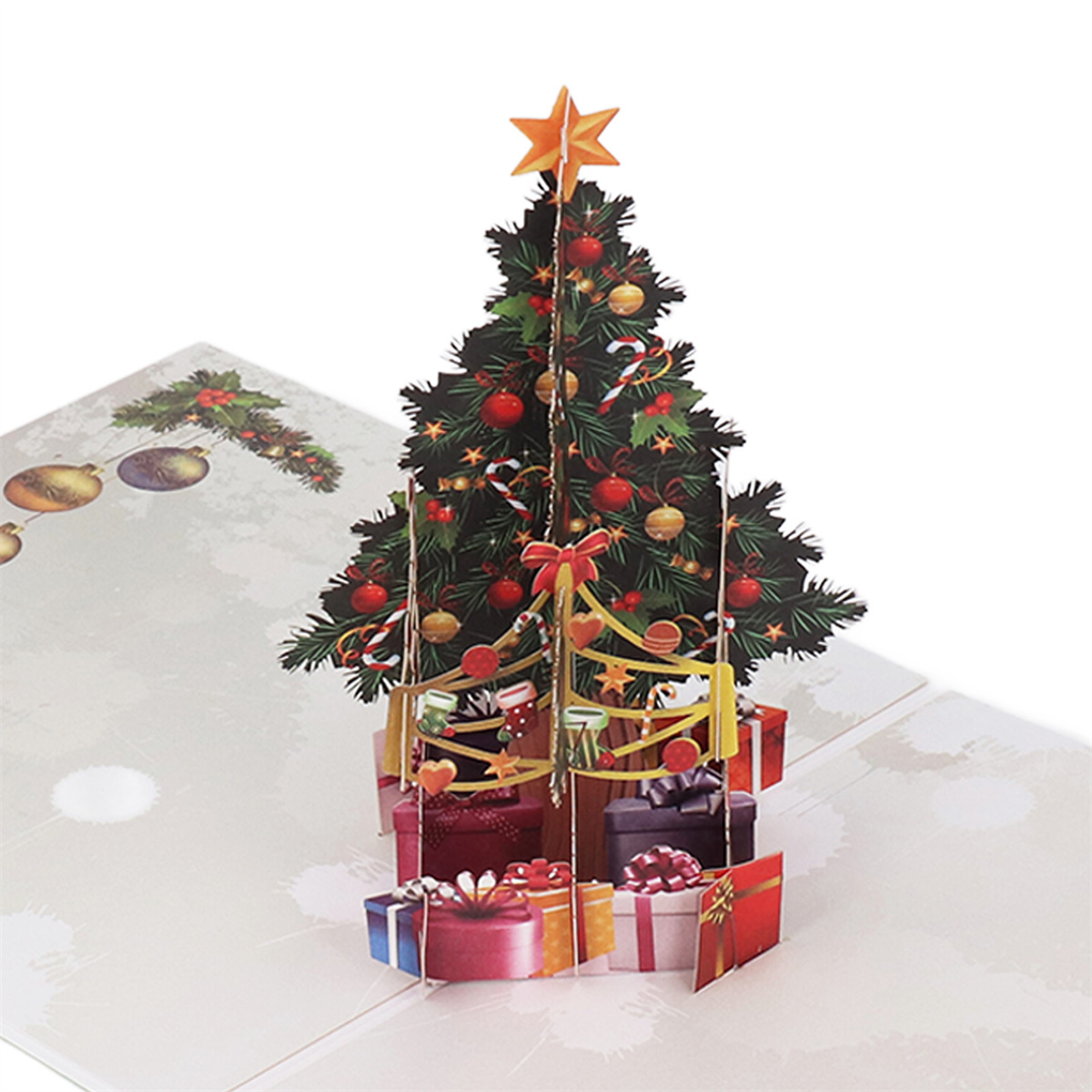 Ein Pop-up-Weihnachtsbaum mit Geschenken darunter und Ornamenten und Sternen am Baum.