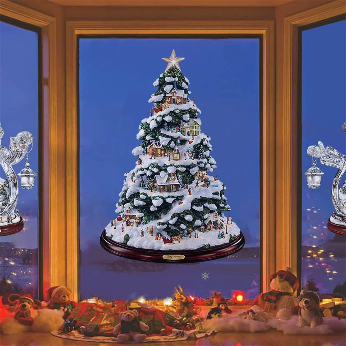 Weihnachtsbaum-Szene in einem Fenster. Der Baum ist geschmückt und von Figuren und Lichtern umgeben. Schneeeffekt.