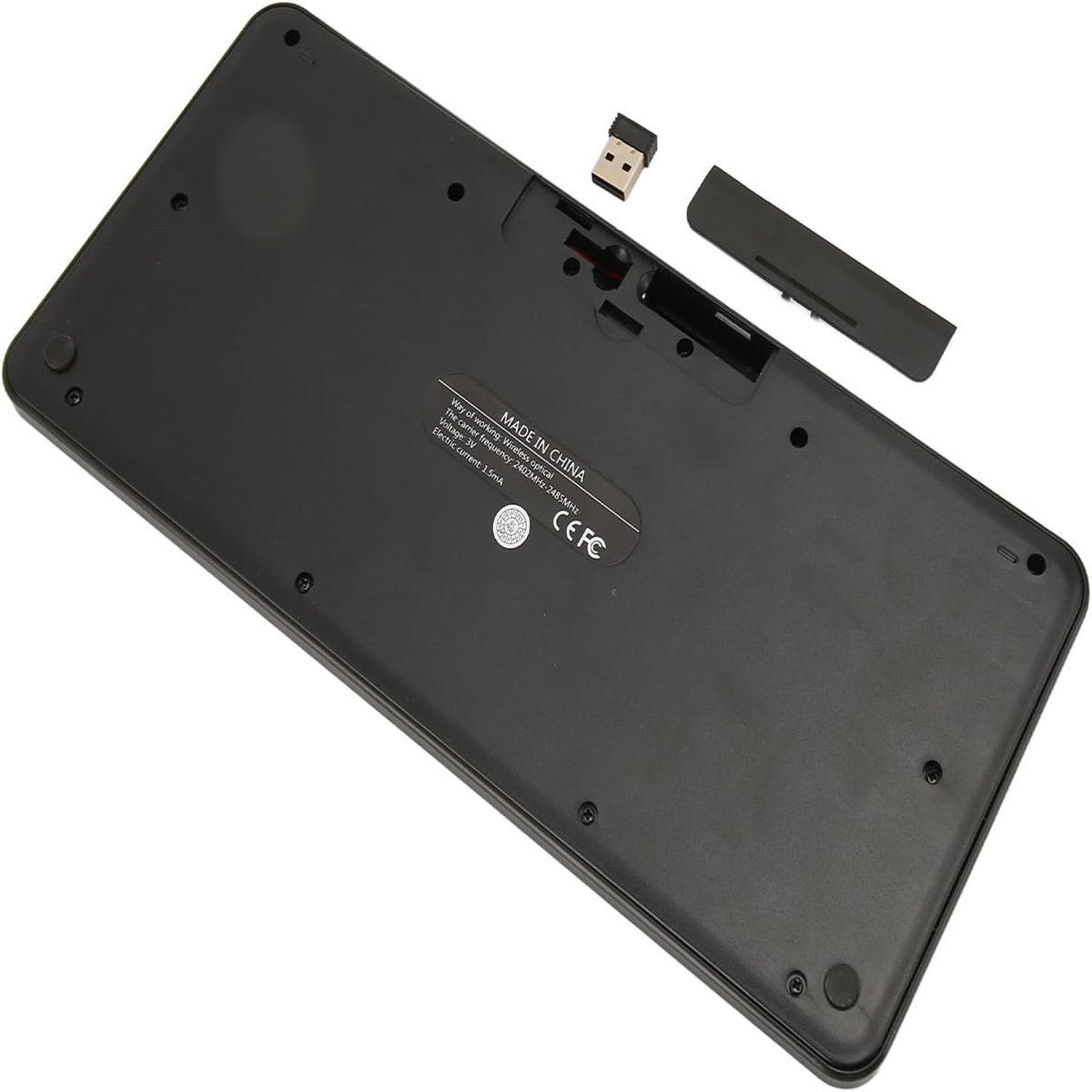 Unterseite einer schwarzen Tastatur mit Rückseite und USB-Empfänger, mit Made in China-Etikett.