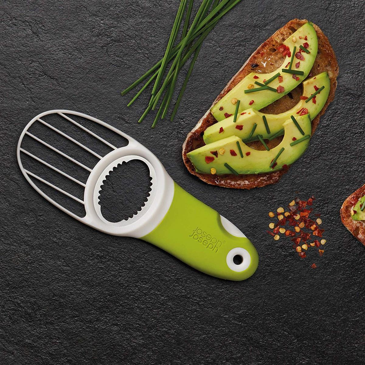Rebanadas de aguacate sobre pan con una herramienta verde y blanca.