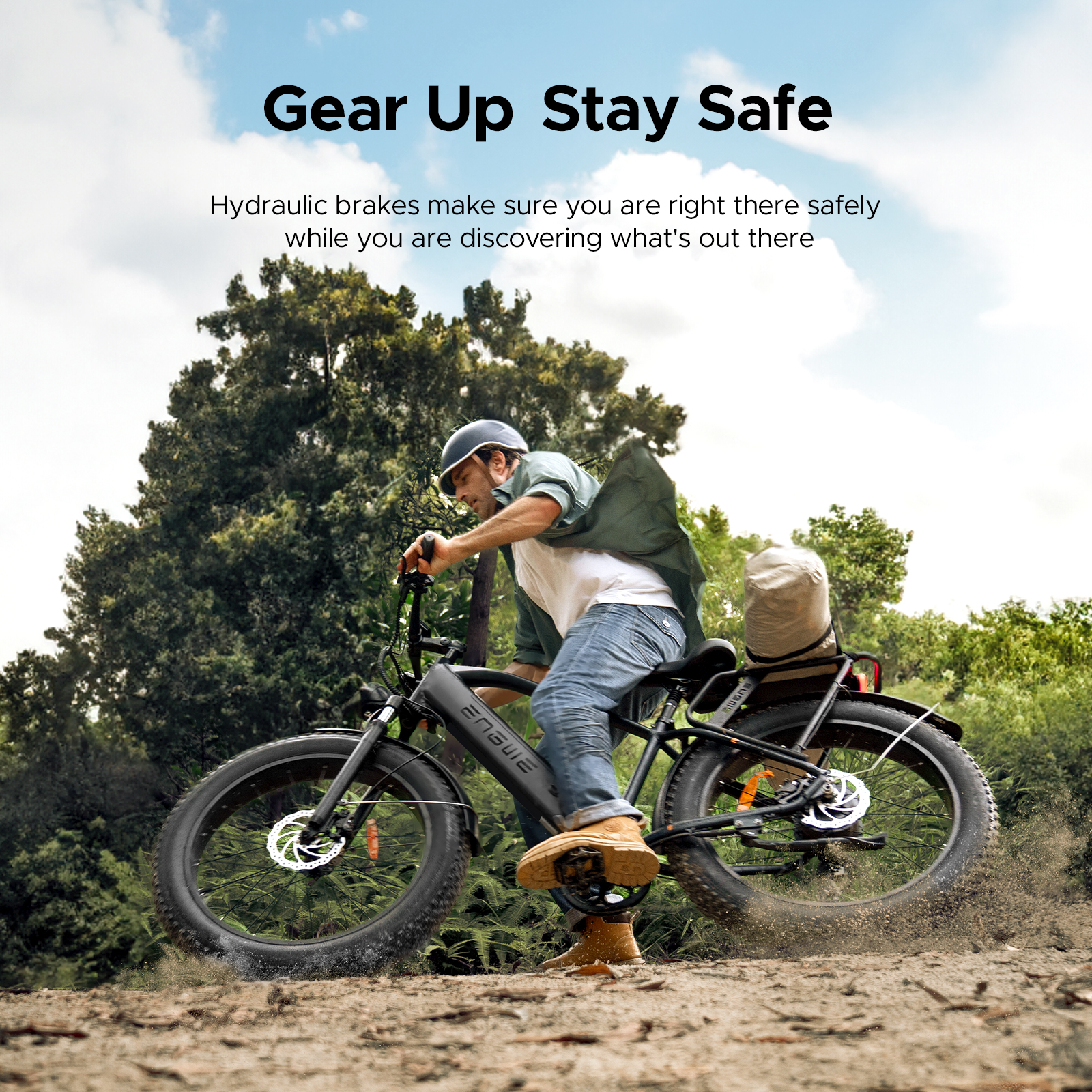 Mężczyzna jadący czarnym rowerem elektrycznym z grubymi oponami na szutrowej ścieżce.