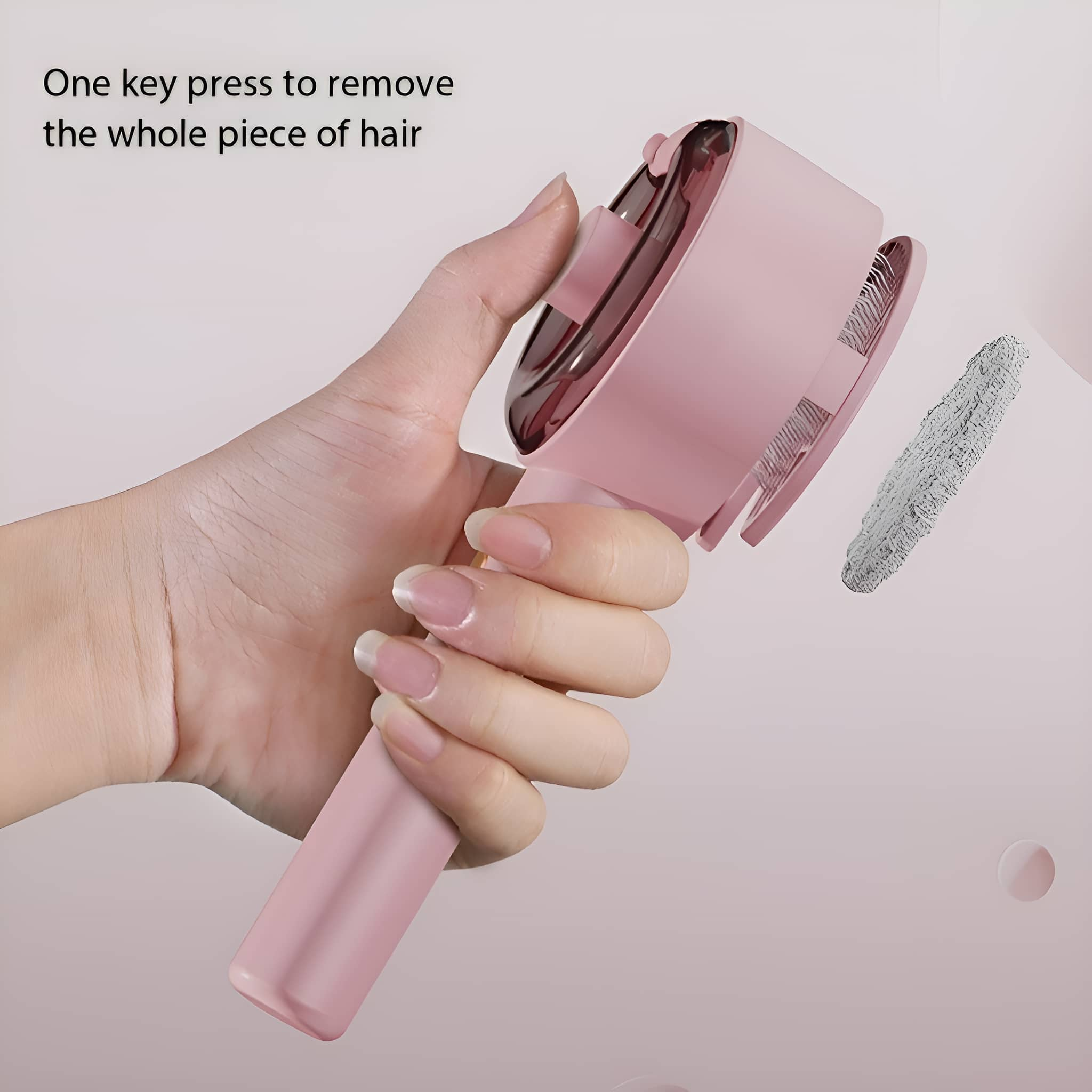 Eine rosa Haarentfernungsbürste mit einer Hand, die sie hält. Ein Haarstück liegt daneben.