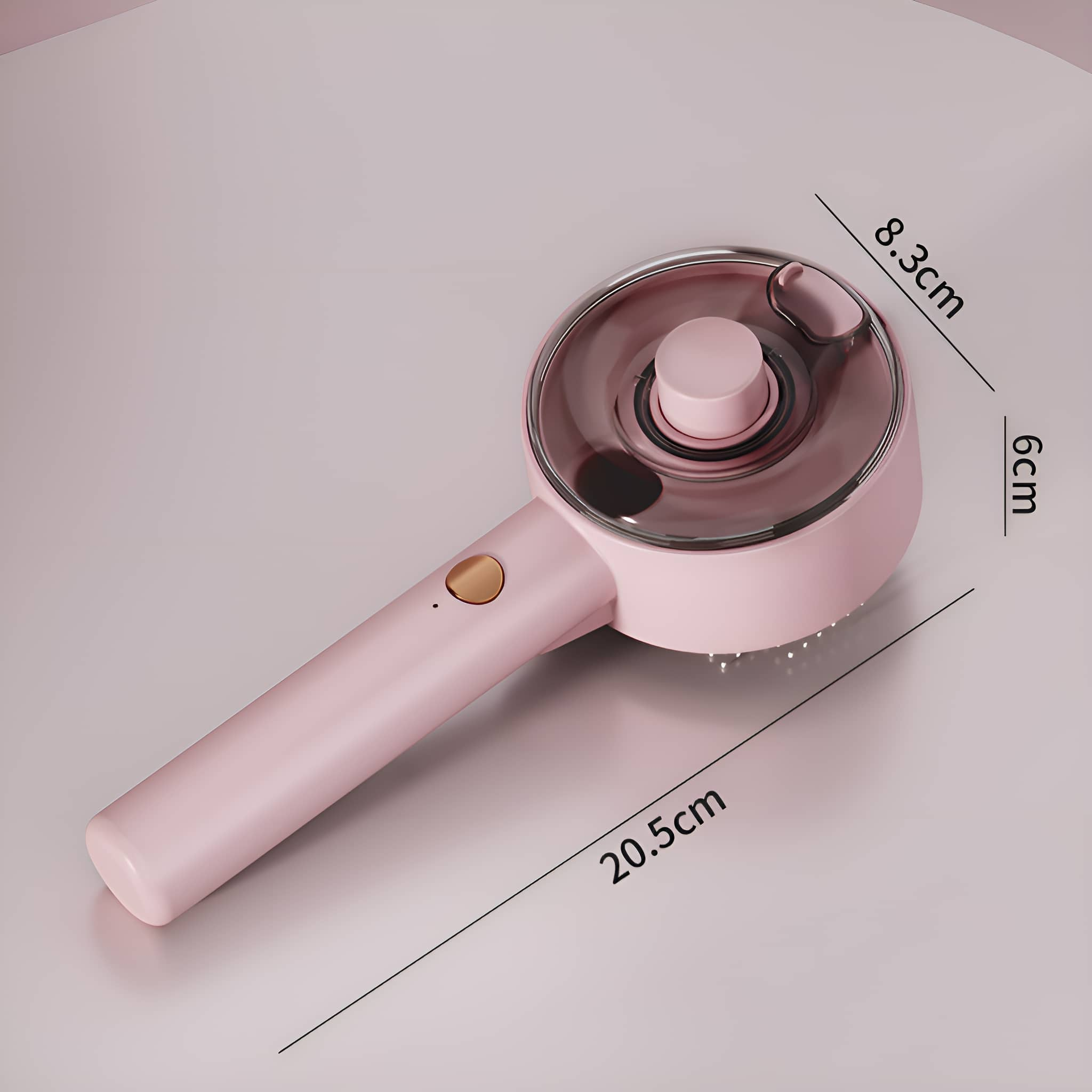 Rosa Massagebürste. Die Bürste ist rund mit einem Griff. Abmessungen sind angegeben. Auf hellrosa Oberfläche.