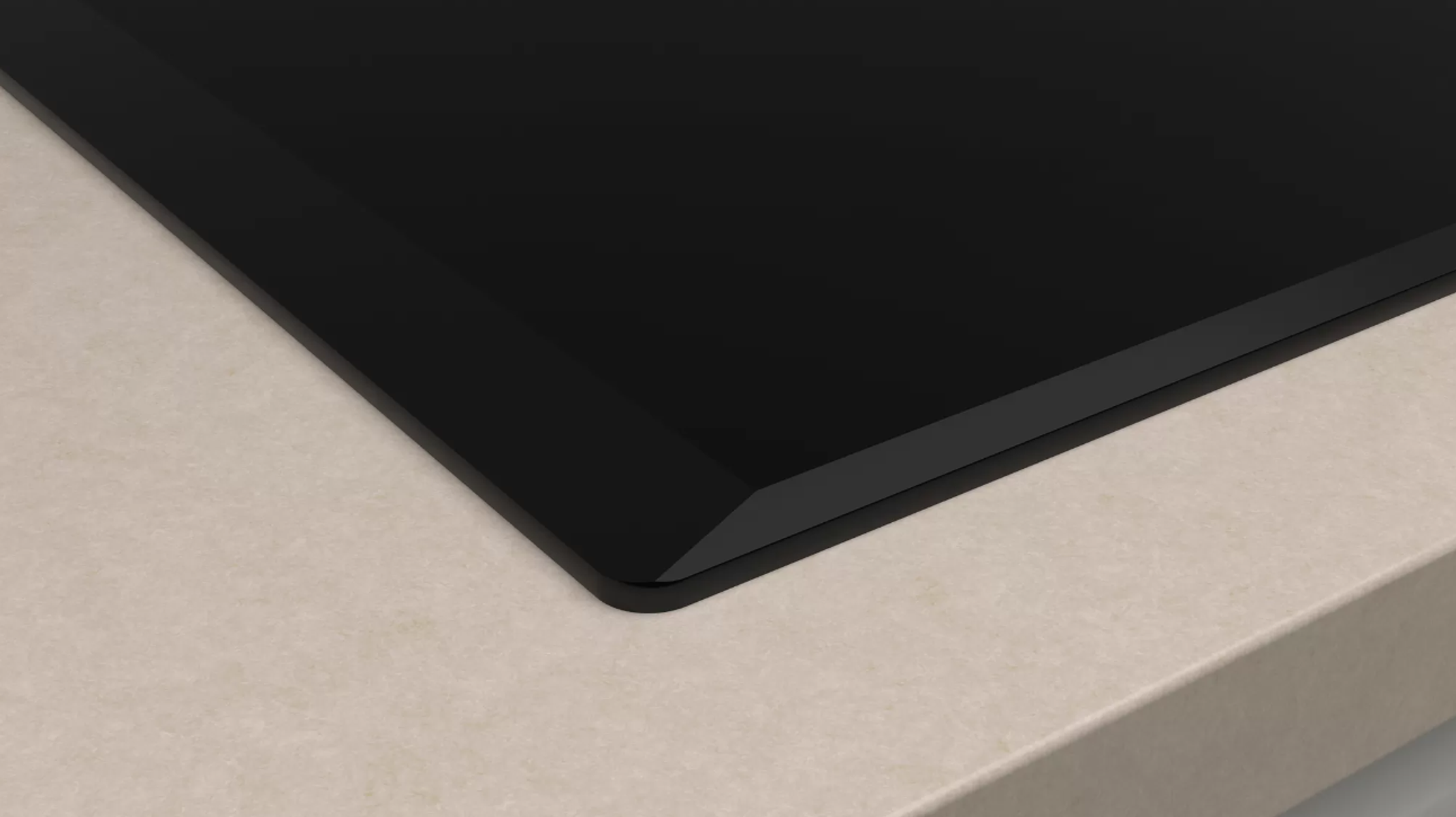 Czarna płyta ceramiczna na beżowym blacie. Widok pod kątem.