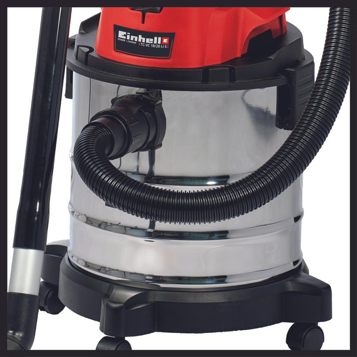 Gros plan d'un aspirateur eau et poussière métallique avec un dessus rouge et un tuyau noir.