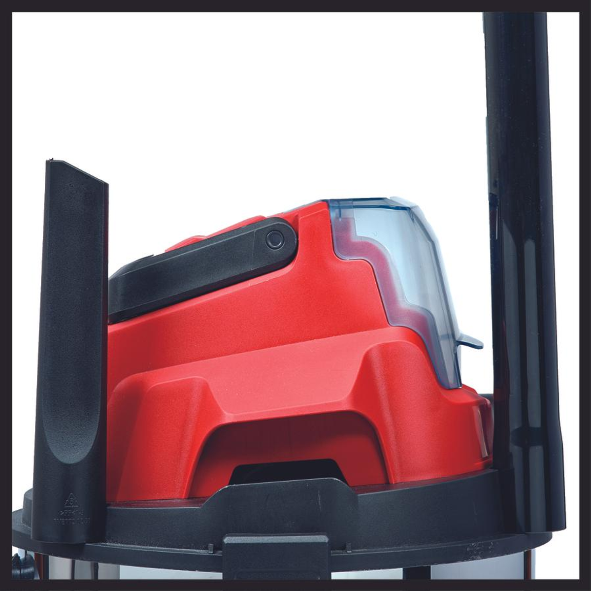 Un aspirateur rouge et noir, avec une poignée et un dessus bleu.