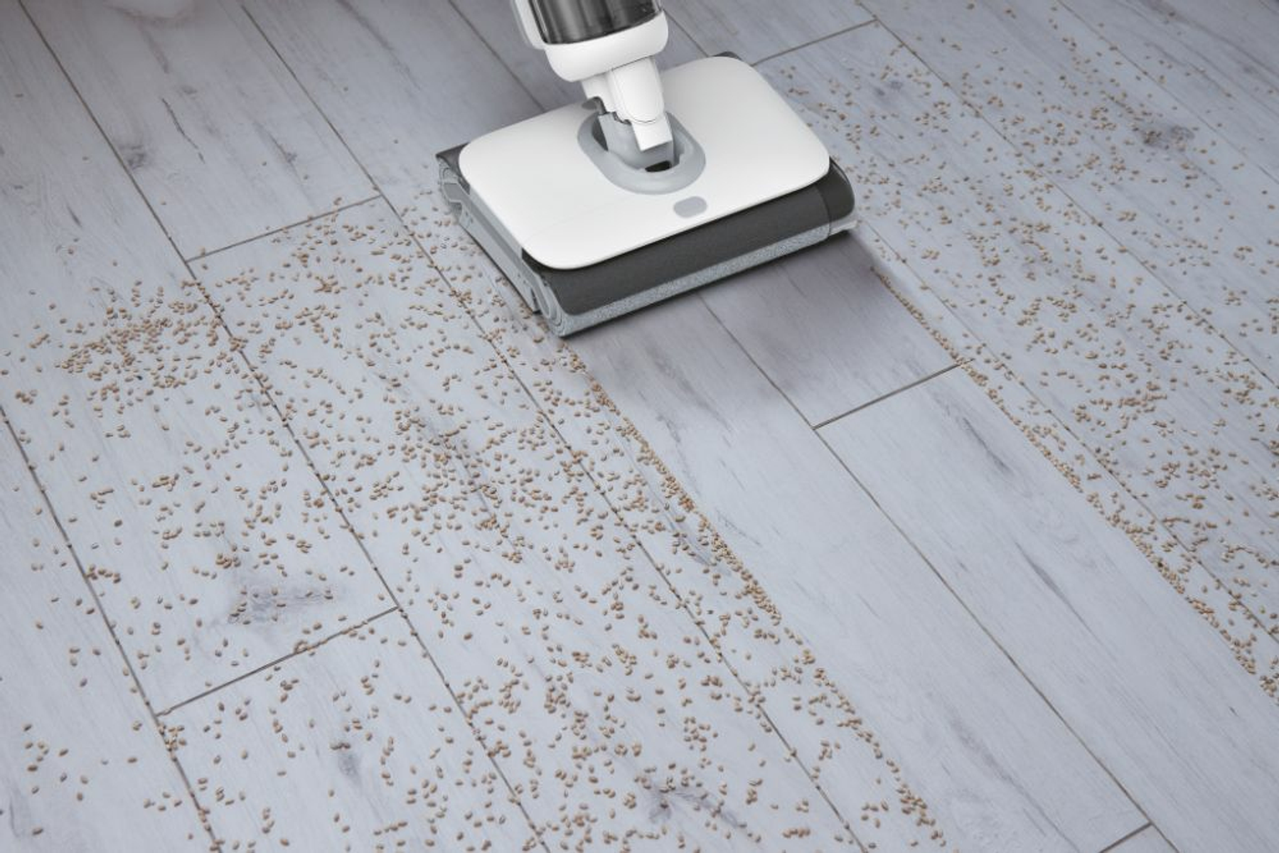 Une machine de nettoyage de sol nettoie un sol recouvert de grains.