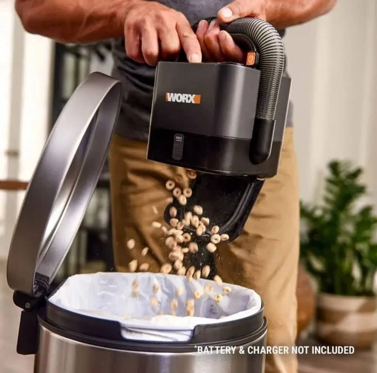 Person entleert einen WORX-Staubsauger in einen Mülleimer. Müsli wird aus dem Staubsauger verschüttet.