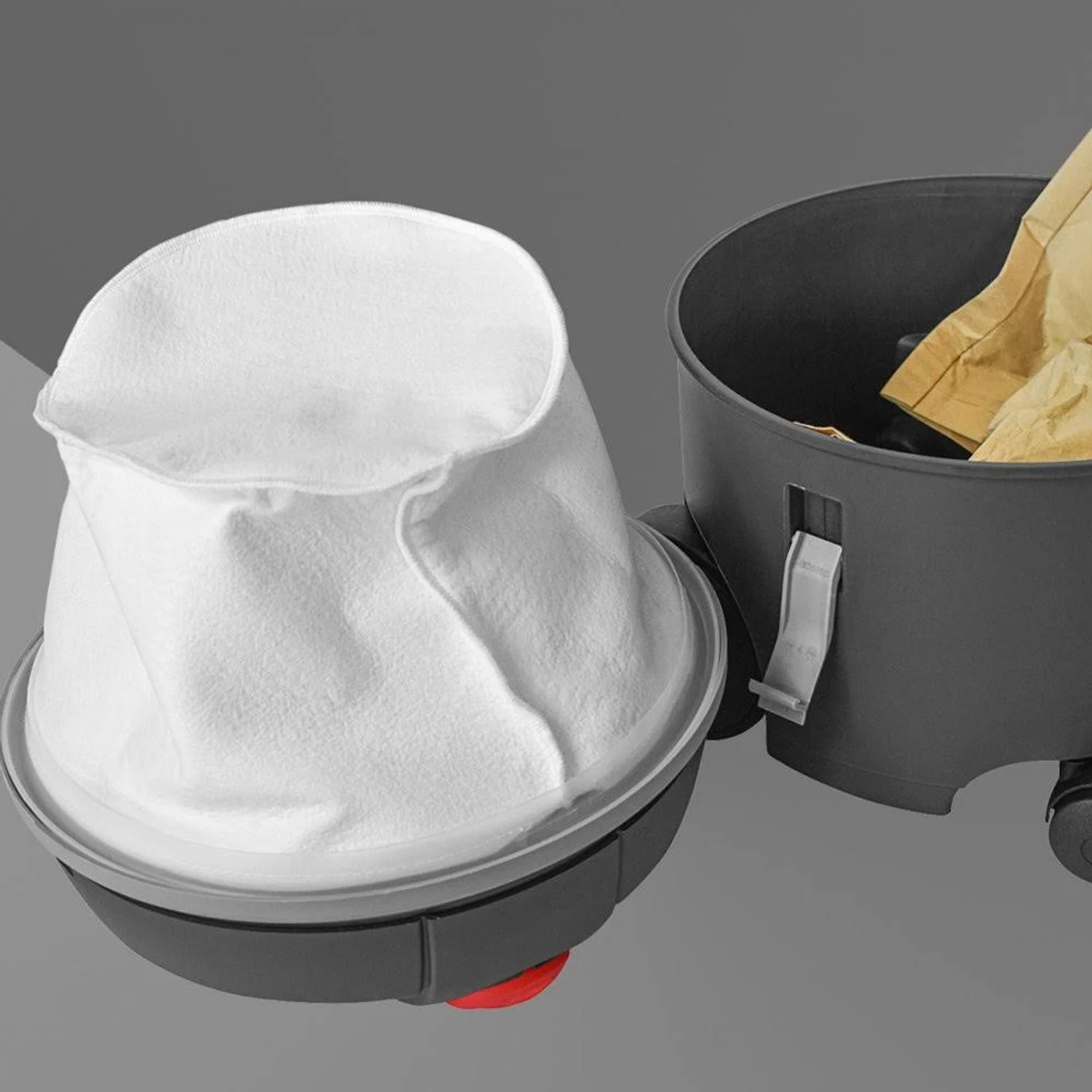 Sacco filtro bianco all'interno di un contenitore per aspirapolvere grigio, accanto a un altro.