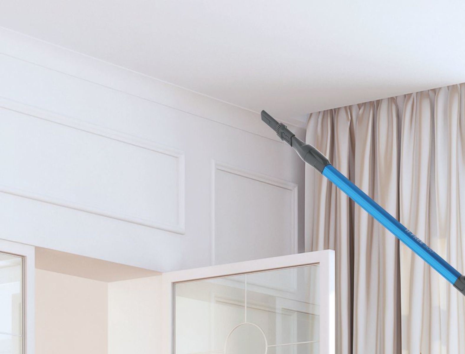 Un'estensione per aspirapolvere blu e nera che pulisce la parte superiore di un muro bianco.